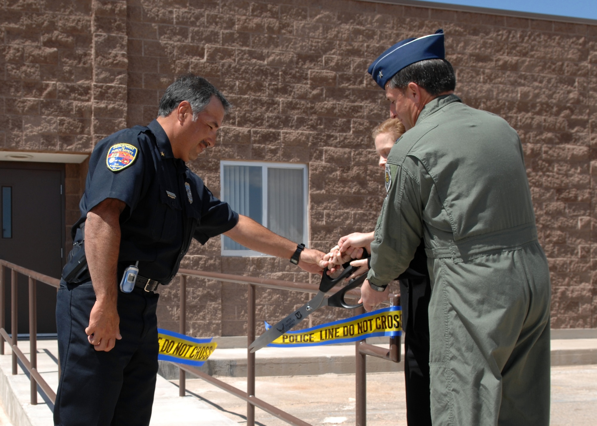 Brig. Gen. David Goldfein, 49th Fighter Wing commander, along with Sarena Carman, Detachment 225 superintendent, and Chief Sam Trujillo, director Alamogordo Department of Public Safety, cut the ribbon leading to the new Holloman Office of Special Investigations building. (U.S. Air Force photo by Airman 1st Class Jamal Sutter)