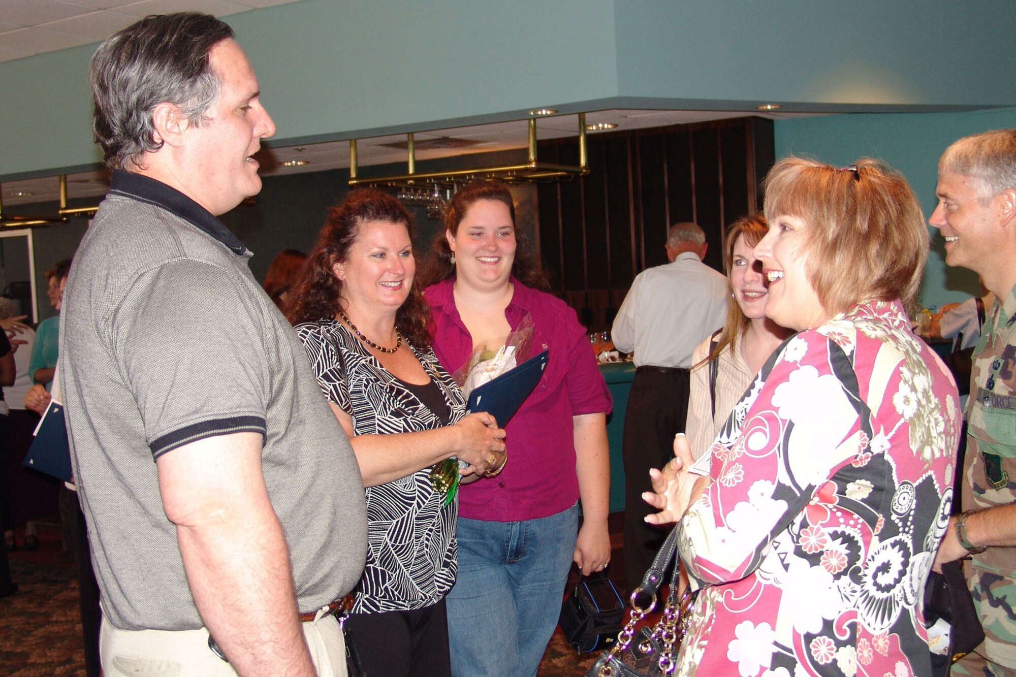 EGLIN AIR FORCE BASE, Fla. -- Mrs. Jane Eidsaune congratulates Eileen Workman and her family for Mrs. Workman's support of the Officers Spouses Club.  Volunteers were recognized at an appreciation ceremony April 17. (Photo by Lois Walsh)