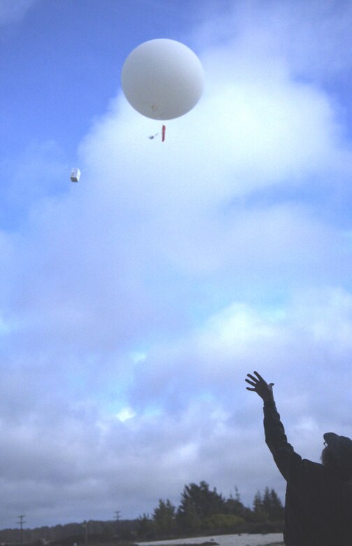 A weather balloon begins its ascent after Brad Barclay releases it from the 30th Weather Squadron building April 11.  The Central Coast Weather Associates contractor uses the balloons for weather forecasting and to provide a snap-shot of the atmosphere when released simultaneously with 300 other sites world wide. (Photo by Airman 1st Class Matthew Plew)