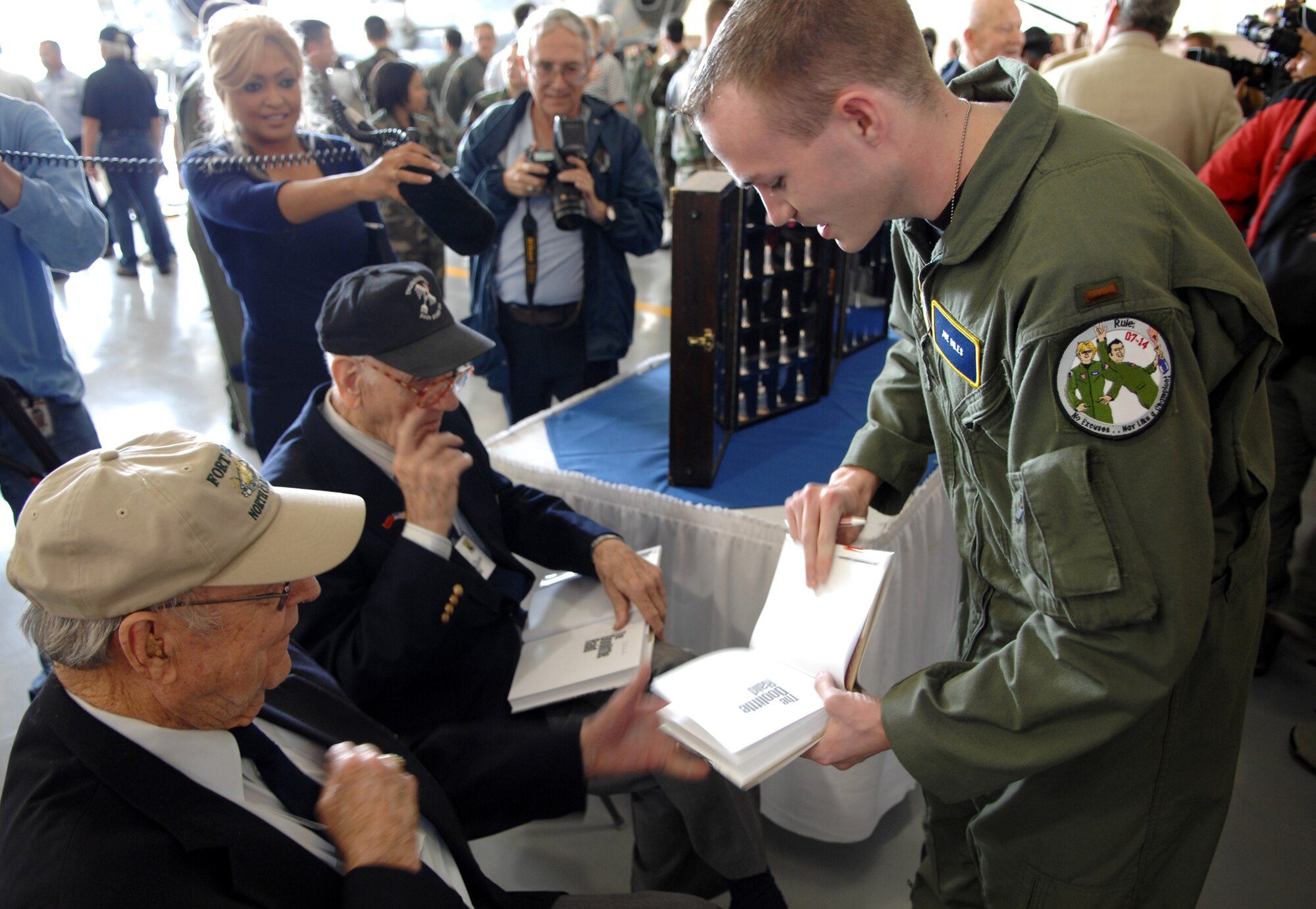 Second Lt. Joe Biles gets his books signed by Doolittle Raiders Robert Hite and Tom Griffin after a ceremony honoring the raiders and celebrating the 65th Anniversary of the raid April 17 at Randolph Air Force Base, Texas. Lieutenant Biles is with the 562nd Flying training squadron at Randolph AFB. The Doolittle Raiders flew B-25 Mitchell bombers over Japan April 18, 1942, just four months after Pearl Harbor. (U.S. Air Force photo/Staff Sgt. Brian Ferguson)