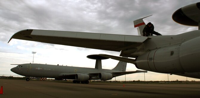 (TINKER AIR FORCE BASE, Okla) An Airman from the 552nd Aircraft Maintenance Squadron conducts post-flight inspections on an E-3B/C Sentry aircraft as its cousin from across the Atlantic - the British E-3D Sentry - taxis to its parking space. Members of the No. 8 Squadron from Royal Air Force Waddington, United Kingdom, conducted a liaison visit to the 552nd Air Control Wing from April 10-17 to open the doors for future mission training and partnership.(Photo by Staff Sgt. Stacy Fowler)