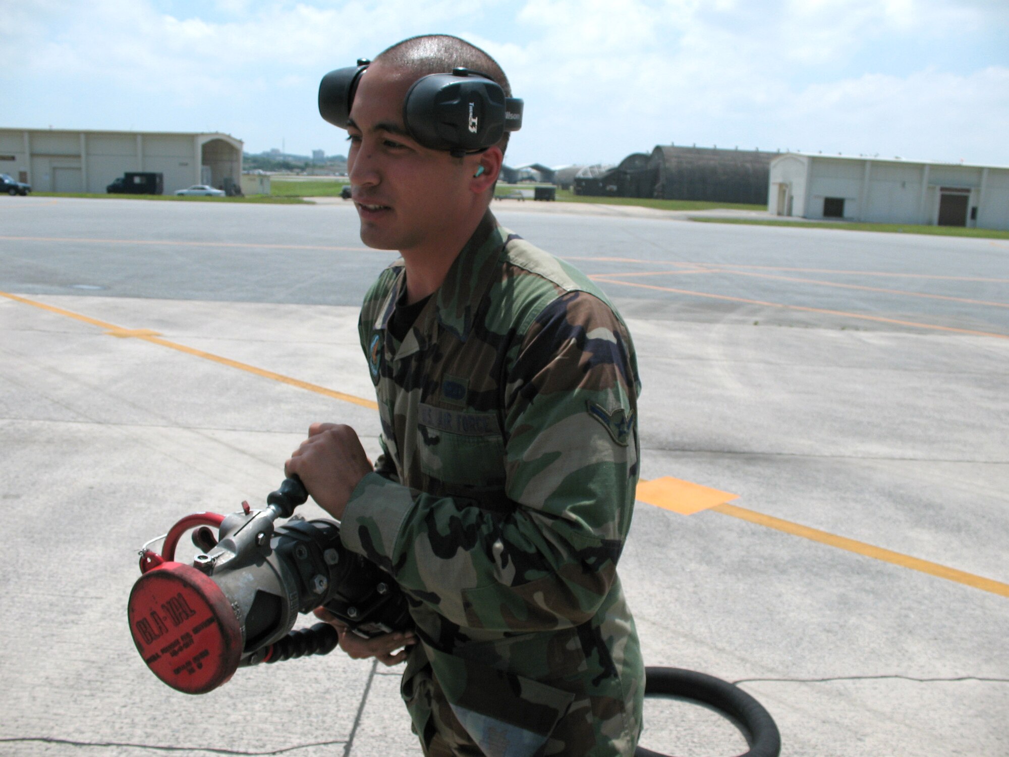 Amn Amery Caoili prepares the fuel hose before F-22 Raptors pull in for gas during hot pit operations at Kadena Air Base, Japan. Hot pits allow fighters to be refueled in a fraction of the time it would take if the aircraft had to be shut off and parked during a normal turn time. Airman Caoili is a fuels distribution operator with 18th Logistics Readiness Squadron. (U.S. Air Force photo/Staff Sgt. Kevin Nichols)