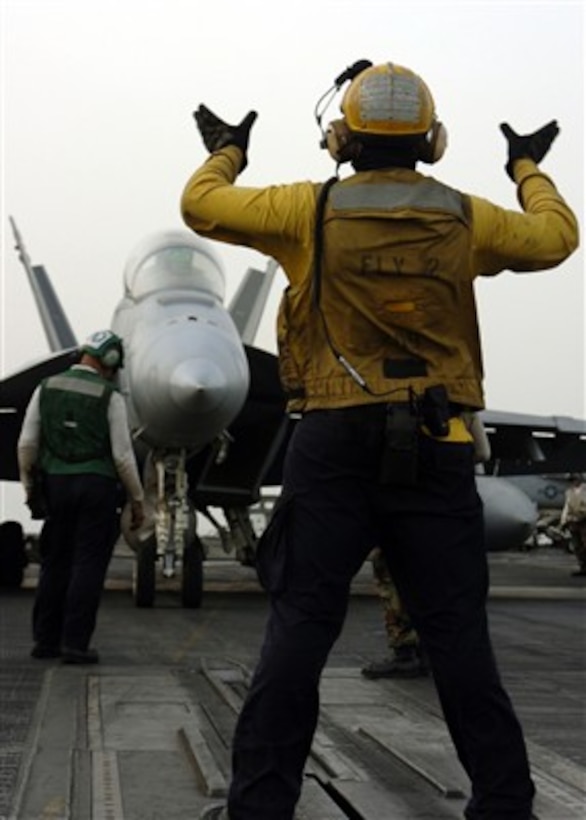 A U.S. Navy plane director guides an F/A-18E Super Hornet aircraft into launch position on the flight deck of the USS Dwight D. Eisenhower (CVN 69) on April 14, 2007.  The Eisenhower and embarked Carrier Air Wing 7 are on deployment in support of maritime security operations in the Arabian Gulf.  