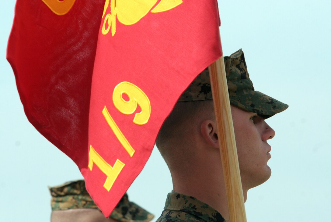 Cpl. Ryan E. Wanner, Headquarters and Support Company, 1st Battalion, 9th Marines, 2nd Marine Division, marches with the company guidon during the pass in review at the unit?s reactivation ceremony held at 10th Marines landing zone April 18. The battalion was first activated in March 1942 and is known for fighting valiantly in many Vietnam campaigns, from Da Nang to Khe Sanh, during their tour of duty.