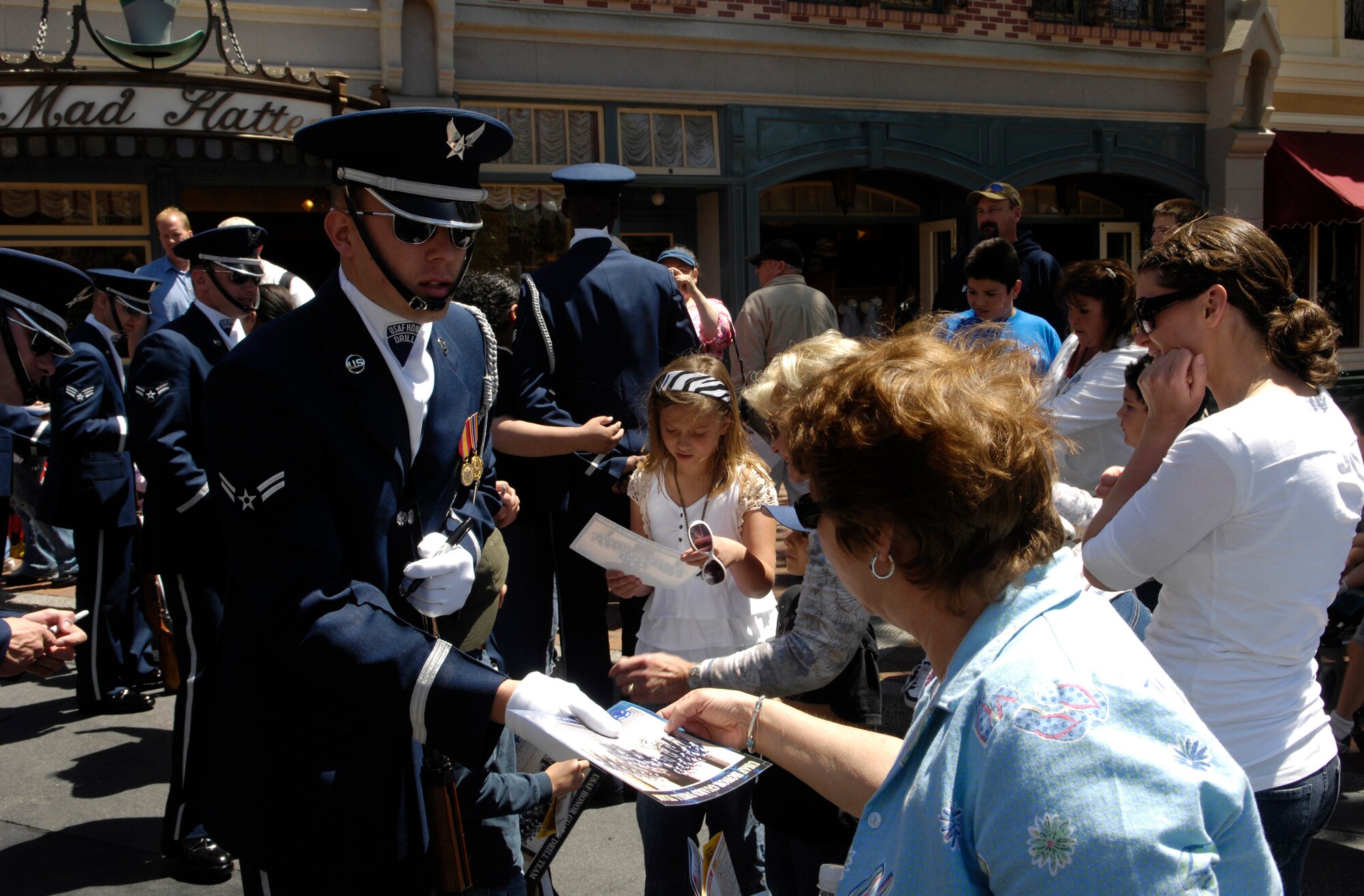 Airman 1st Class Mike McCabe, Air Force Honor Guard Drill Team member, signs autographs and talks about the Air Force with an audience member after performing in a 16 Man drill routine at Disneyland Resort in Aneheim, Calif., 18 April 2007. The Drill Team is the traveling component of the Air Force Honor Guard and tours Air Force bases world wide showcasing the precision of today's Air Force to recruit, retain, and inspire Airmen for the Air Force mission. (U.S. Air Force photo by Senior Airman Daniel R. DeCook)(Released)
