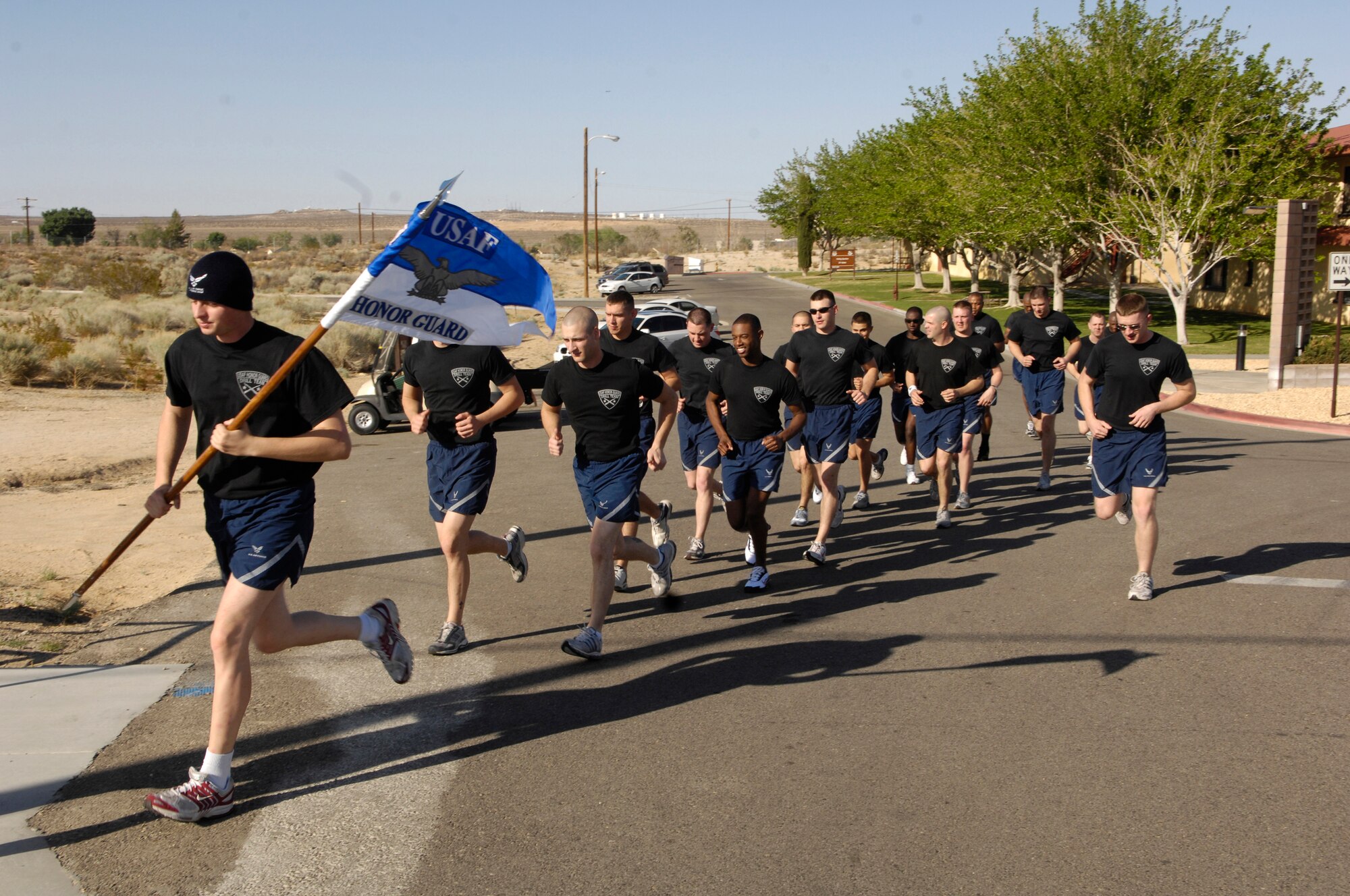 Members of the Air Force Honor Guard Drill Team, with guidon in hand, take off for a formation run while visiting at Edwards AFB, Calif. on 18 April 2007.  The Drill Team is the traveling component of the Air Force Honor Guard and tours Air Force bases world wide showcasing the precision of today's Air Force to recruit, retain, and inspire Airmen for the Air Force mission. (U.S. Air Force photo by Senior Airman Daniel R. DeCook)(Released)
