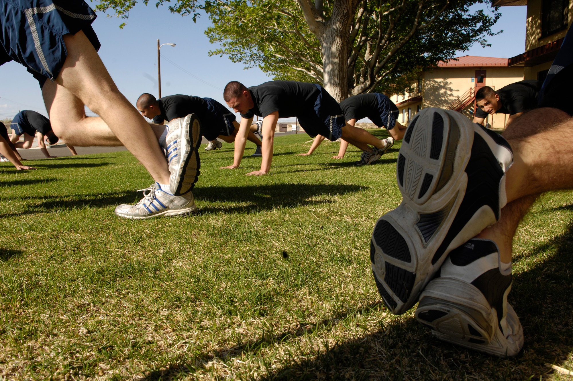 Members of the Air Force Honor Guard Drill Team conduct a group physical training session outside the High Desert Inn at Edwards AFB, Calif. on their recent tour.  Often on the road, these Airmen make use of whatever running and workout space is available to ensure they stay "fit to fight" even as they visit AF bases across the country. (U.S. Air Force photo by Senior Airman Daniel R. DeCook)(Released)