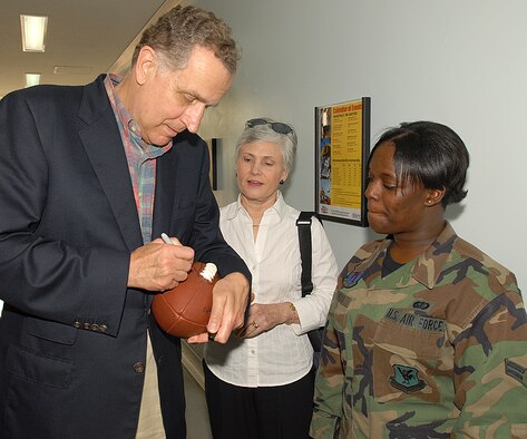 KADENA AIR BASE, Japan -- Paul Tagliabue, former NFL Commissioner, signs a football for Airman 1st Class Keyatta Tolbert, 18th Services Squadron, at the Risner Fitness Center during his visit to Kadena. Mr. Tagliabue toured the base to learn about Kadena's mission.  He also met with Airmen at the Risner Fitness Center. (Air Force/Airman 1st Class Kasey Zickmund)
