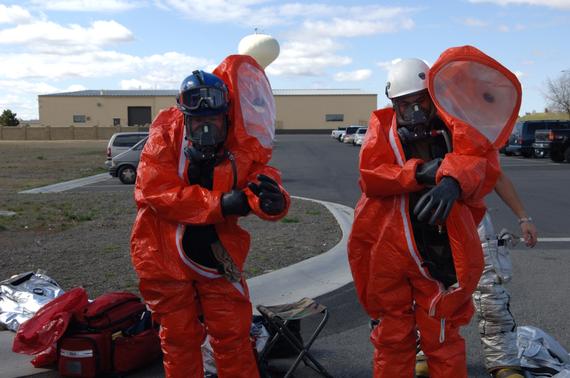 FAIRCHILD AIR FORCE BASE, Wash. -- John Adams and Senior Airman David Adriatico don protective suits in preparation to enter a simulated hazardous area during an exercise to test the base abilities to respond to a weapon of mass destruction here April 19. Mr. Adams and Airman Adriatico are both members of the 92nd Civil Engineer Squadron.(U.S. Air Force photo/Airman 1st Class Jocelyn Ford)
