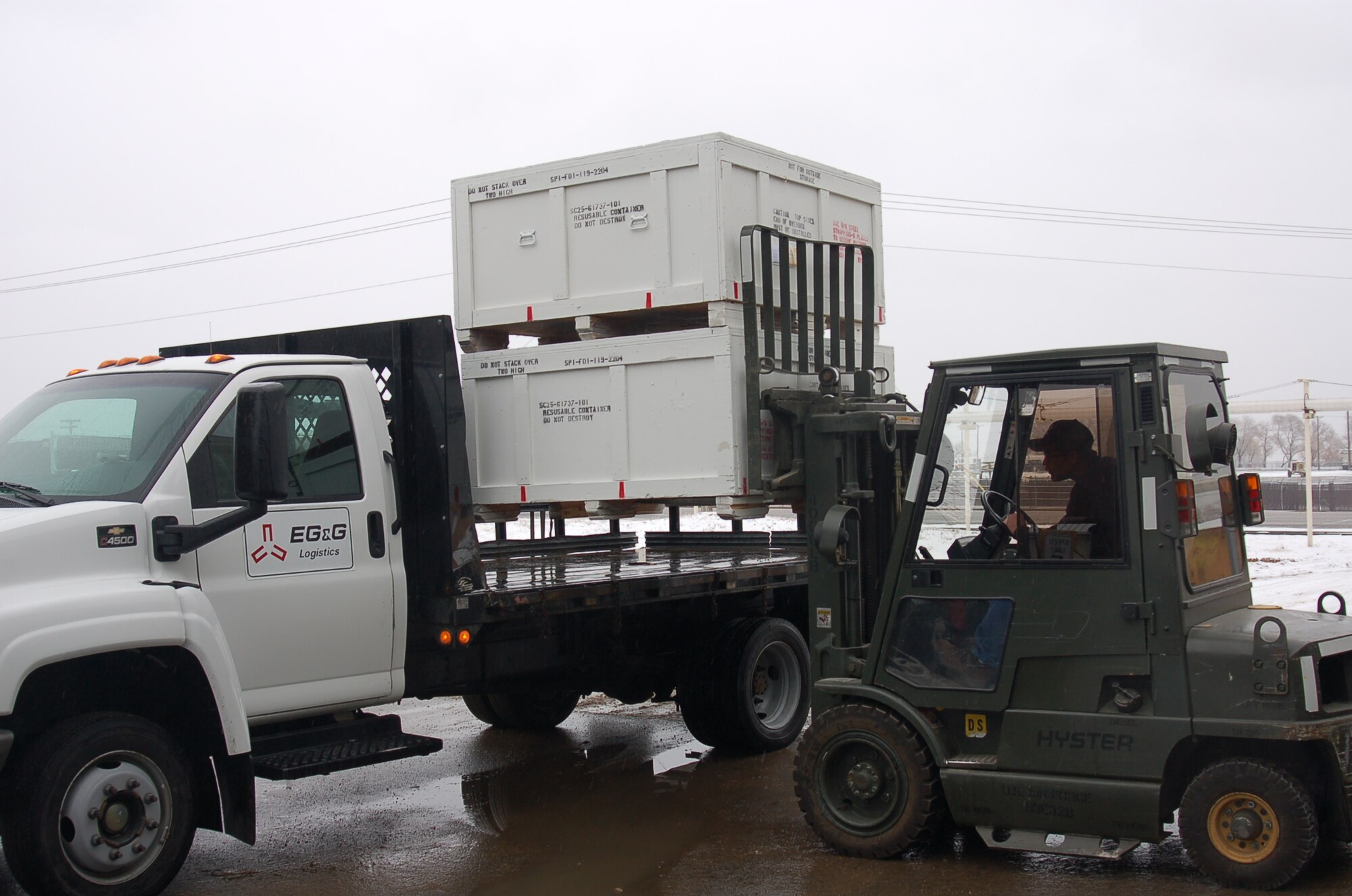 Reusable shipping containers, custom built and painted in the 309th Maintenance Support Group's Pattern Making/Wood Products Support Element, are loaded onto a truck by Max Fowles, pattern maker. Photo by Bill Orndorff
