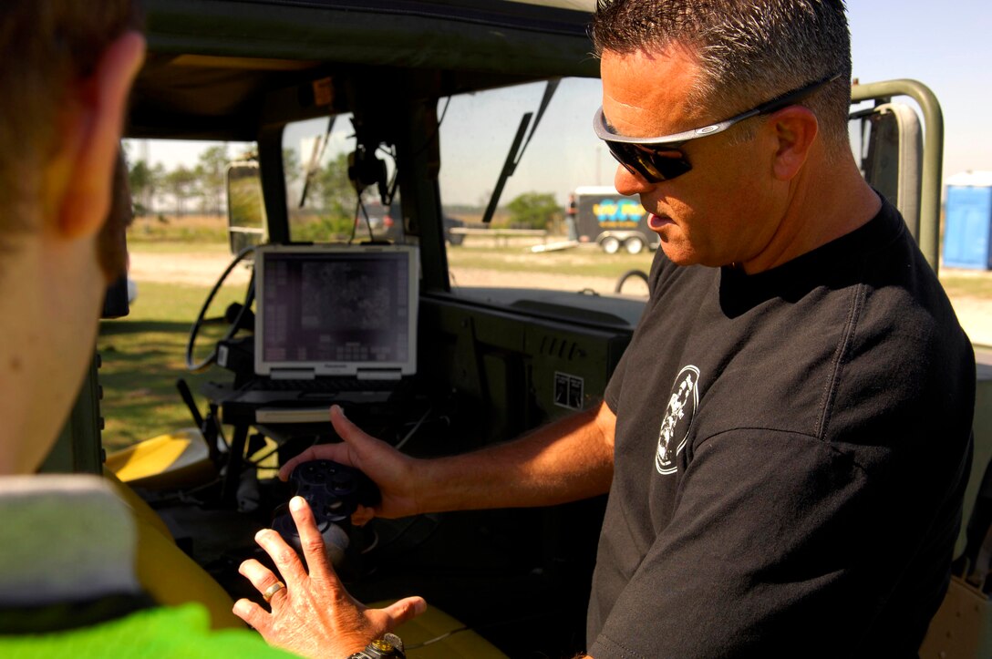 Bob Raulerson, a marketing manager from Northrop Grumman, demonstrates the capabilities of "Venom", a remote controlled lightweight laser designator rangefinder on April 17 prior to using it in Atlantic Strike 5. Atlantic Strike is a joint forces training semi-annual event held involving Joint Terminal Attack Controllers, or JTACs from the Air Force, Army and Marines at Avon Park Air Ground Training Complex in Avon Park, Fla. (U.S. Air Force photo/Staff Sgt. Stephen J. Otero)