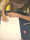 Ashlyn Daniels, a fourth-grader at Lackland Elementary School, Lackland Air Force Base, Texas, sketches the design for her Earth Day drawing during art class April 12. The artwork will be taped to paper grocery bags and distributed at the commissary in observance of Earth Day. Ashlyn is the daughter of Jamie and Tech. Sgt. Tracy Daniels. (USAF photo by David Garcia)