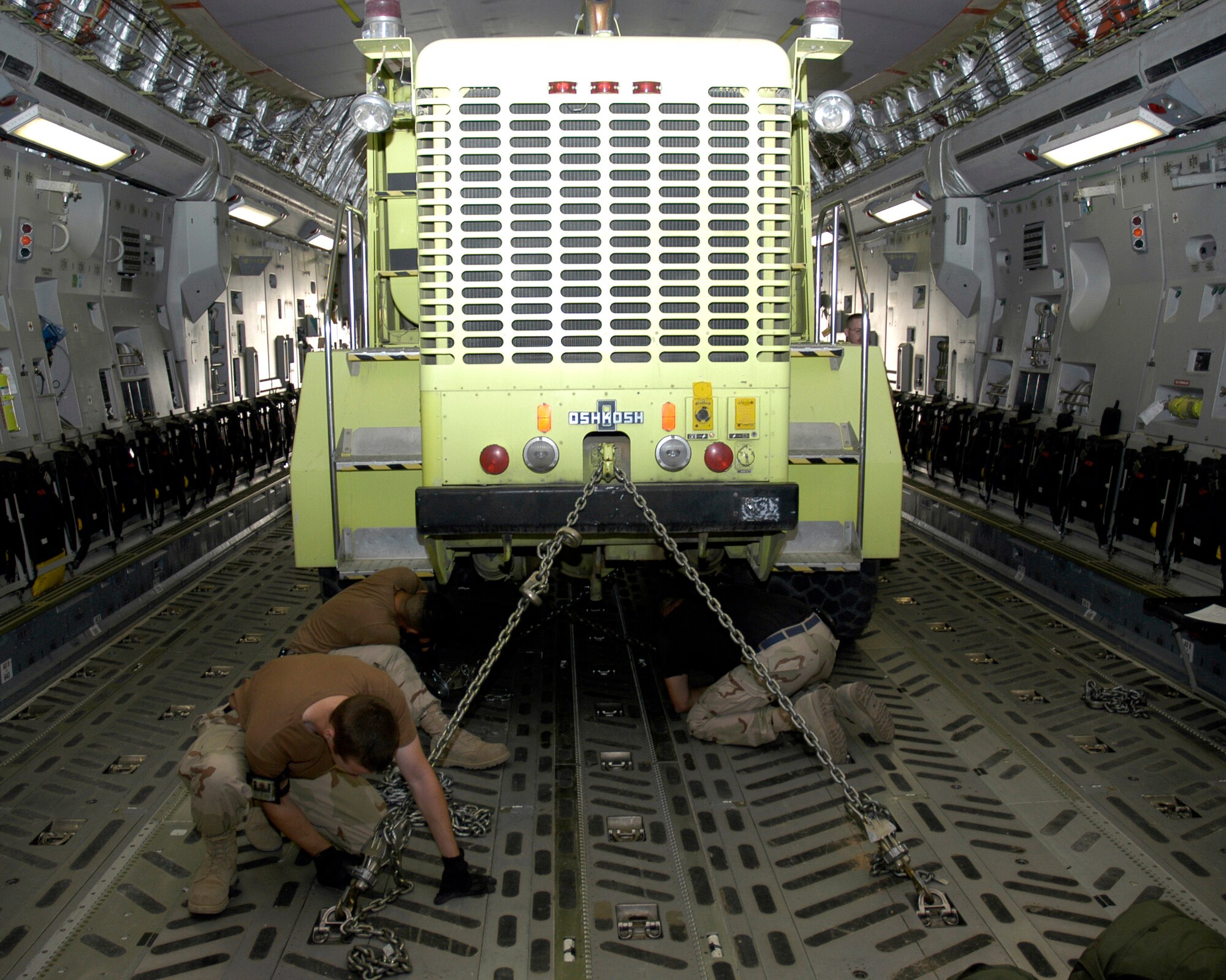 Airmen from the 386th Expeditionary Logistics Readiness Squadron use chains to secure a fire and rescue truck April 19 inside a C-17 Globemaster III in Southwest Asia. The truck is one of two donated by Baltimore officials and bound for Mazar-i-Sharif Airport in Northern Afghanistan. (U.S. Air Force photo/Staff Sgt. Ian Carrier)