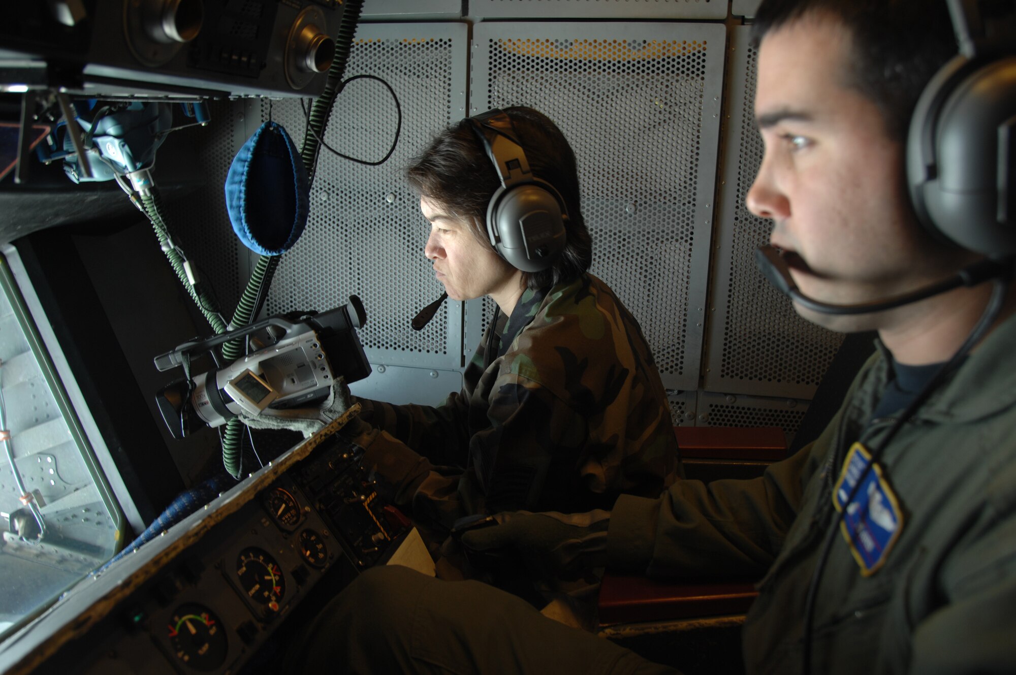 EIELSON AIR FORCE BASE, Alaska -- Technical Sgt Grace Lamoureux (left), 354th Communications Squadron, Eielson Air Force Base, Alaska records a Navy F/A-18 from Strike Fighter Squadron Eight Seven (VFA-87) refueling behind KC-10 Extender, call sign "Shaman Five One"  while Staff Sgt Angel Gomez, KC-10 Boom Operator, 78th Air Refueling Squadron, McGuire Air Force Base, New Jersey operates the drouge during a refueling mission here on 18 April in support of Red Flag-Alaska 07-1. Red Flag-Alaska is a Pacific Air Forces-directed field training exercise for U.S. forces flown under simulated air combat conditions. (U.S. Air Force photo by Staff Sgt. Joshua Strang)