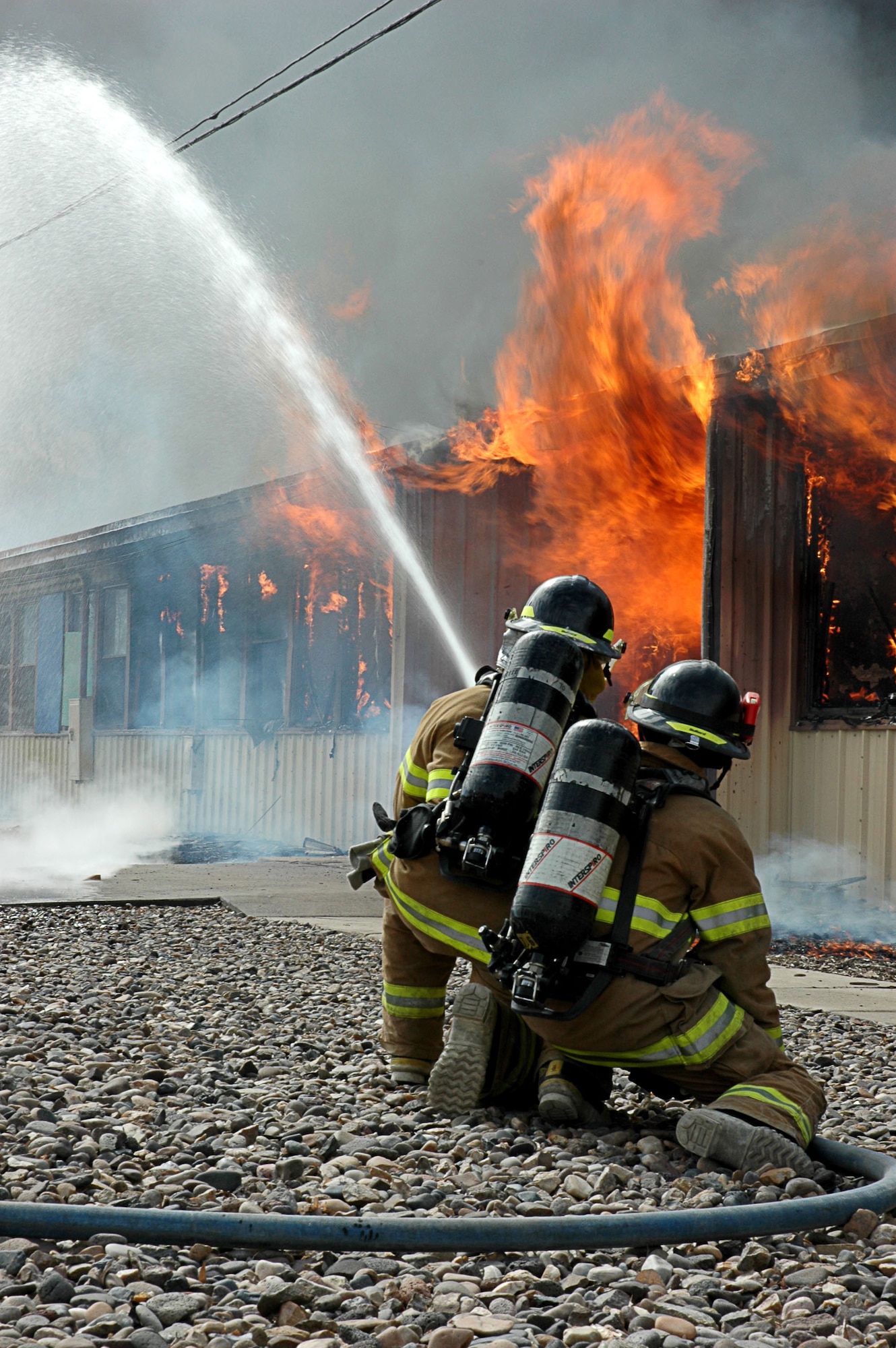 MOUNTAIN HOME AIR FORCE BASE, Idaho -- Firefighters here combat a controlled fire at Bldg. 1612 April 12.  Already scheduled for demolition, the fire department used the building to train its fire fighters with the final burn bringing down the entire structure April 12.  Air Force photo by Airman Samantha S. DeVries