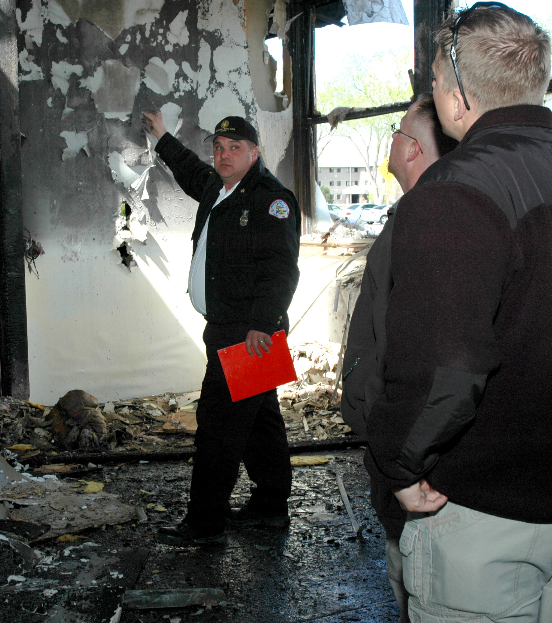 MOUNTAIN HOME AIR FORCE BASE, Idaho -- John Walker, base fire department assistant chief of fire prevention, talked with agents from the base's Air Force Office of Special Investigations detachment April 10 at Bldg. 1612.  The walk through helped familiarize the agents on conducting fire investigations and to determine what caused the fire.  Air Force photo by Airman Samantha S. DeVries