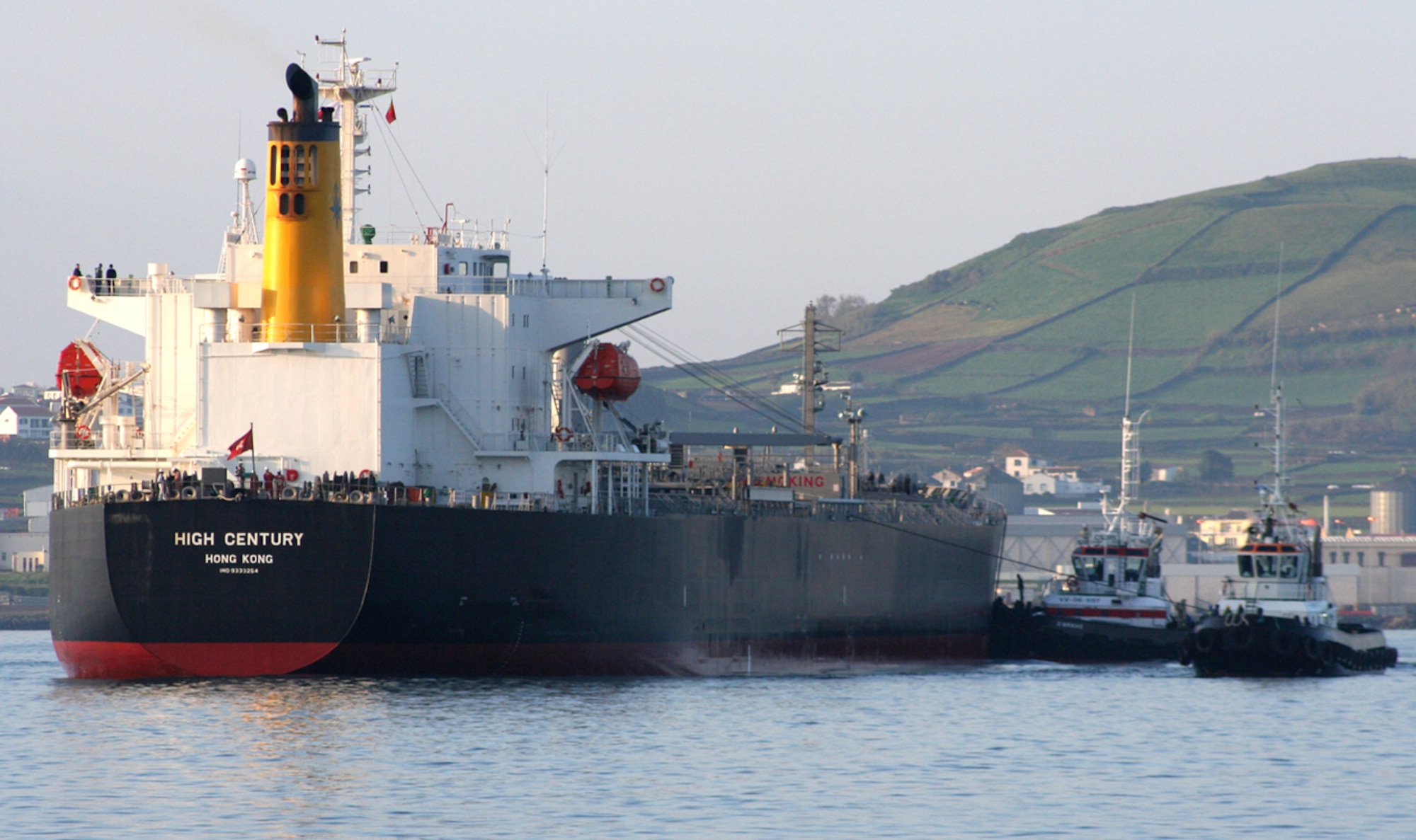 PRAIA DA VITORIA, Azores, Portugal -- The High Century, left, pulls into the bay here with the support of two tugboats April 4, 2007. (U.S. Air Force photo by Staff Sgt. Marcus McDonald)