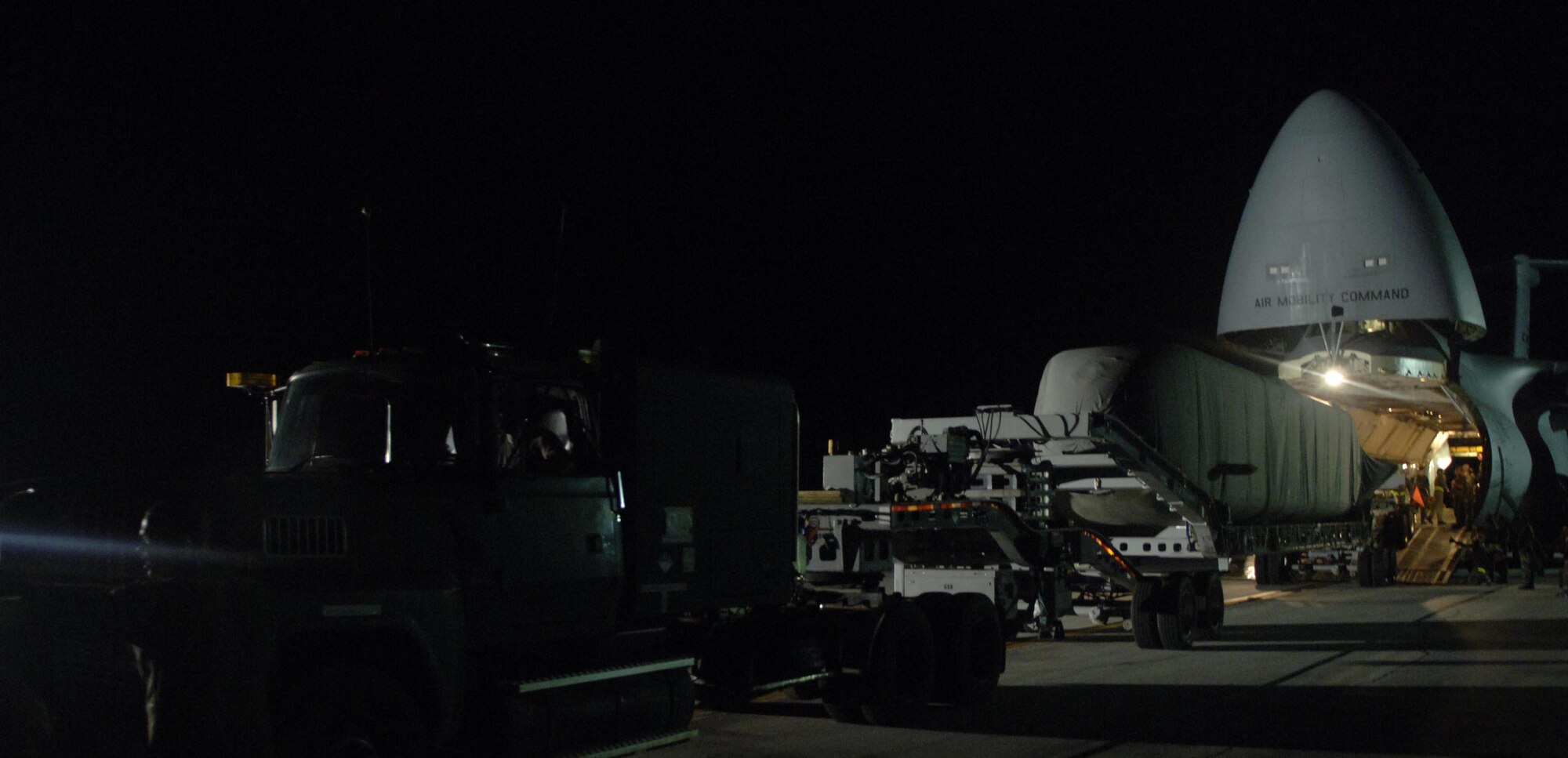 An Advance SEAL Delivery System, a 65-foot nature submarine, is dwarfed by the C-5 Galaxy used to deliver it.  (Below) Airmen from the 734th Air Mobility Squadron helped the aircrew from the 22nd Airlift Squadron off-load the ASDS.  (Photos by Staff Sgt. Patrick Mitchell/36th Communications Squadron)