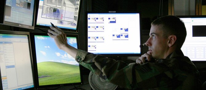 Senior Airman Joe Tesznar, 36th Security Forces Squadron electronic security systems noncommissioned officer, monitors CCTV and 'Object Video' display panels.  Photo by Master Sgt. Wes Willand/ 36th SFS)