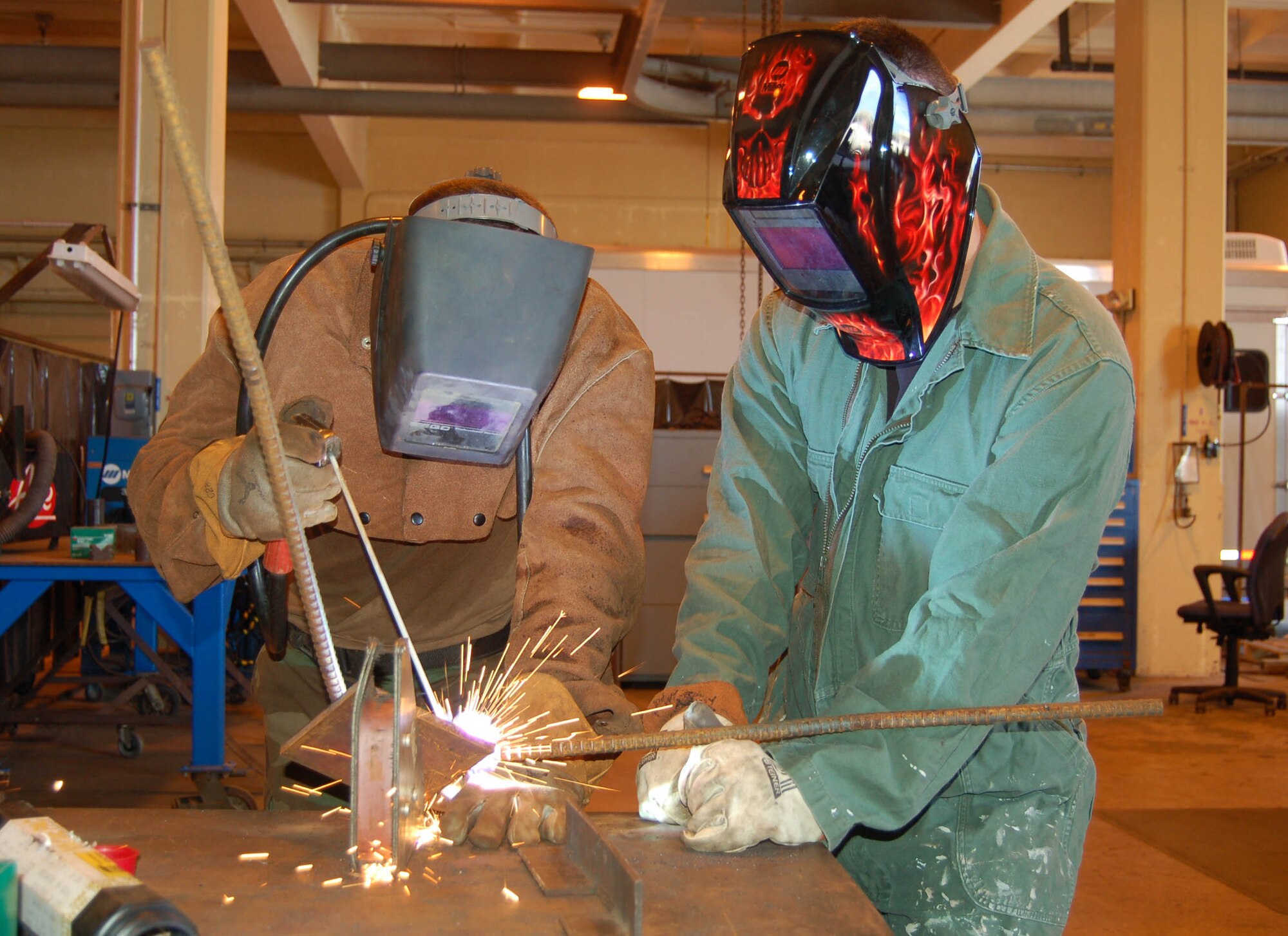 A 554th RED HORSE Squadron member welds an embed for a concrete panel, while a 36th MXS member watches closely. The 554th RED HORSE Squadron and the 36th Maintenance Squadron are working together to accomplish a common goal — the mission. In this particular mission, the 554 RHS needs to use the 36th MXS Metals Technology Shop so they can make metal embeds that will be used for constructing buildings at Northwest Field, the future 554 RHS home. (Photo by Airman Basic Evan Carter/36th Wing Public Affairs)