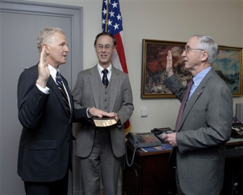 Deputy Secretary of Defense Gordon England (right) administers the oath of office to newly appointed Assistant Secretary of Defense for Health Affairs Dr. Ward Casscells (left) during a Pentagon ceremony on April 16, 2007.  Holding the Bible is Under Secretary of Defense for Personnel and Readiness David S. C. Chu (center).  
