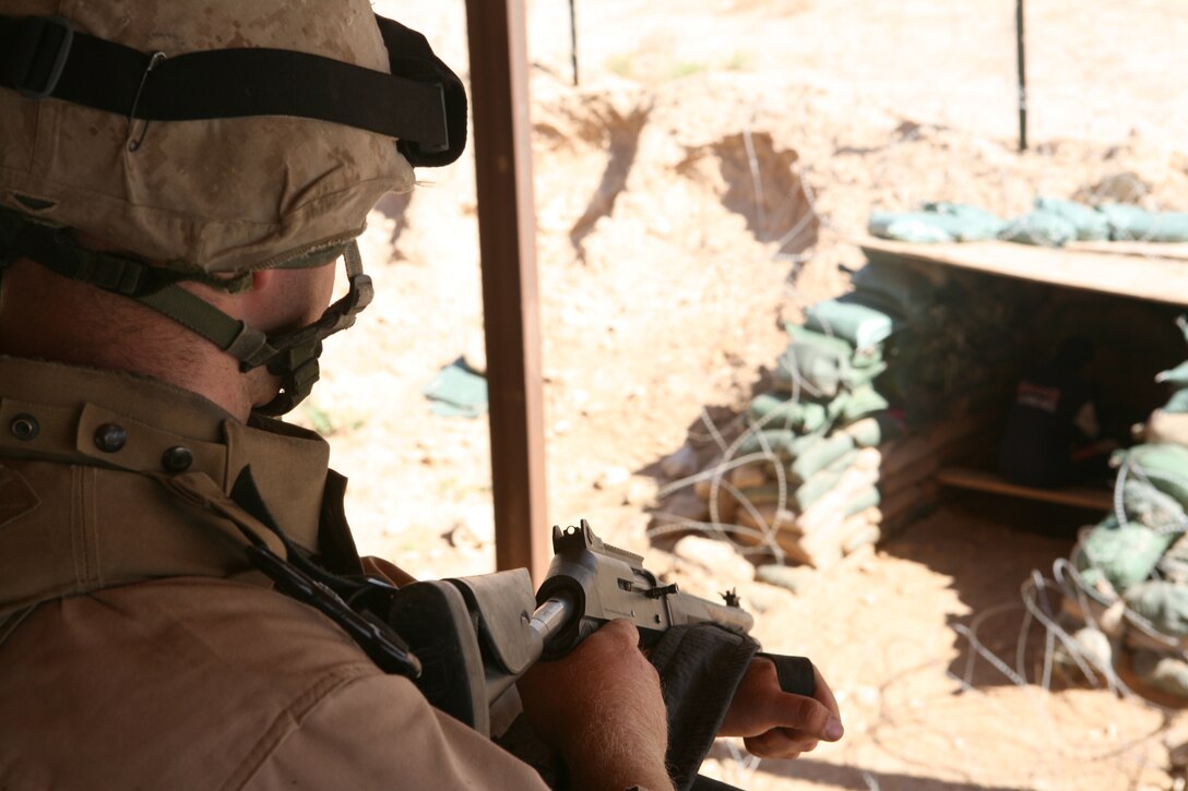 AL ASAD, Iraq- LCpl. Josh Buckner, a Bravo Battery, 2nd Low Altitude Aircraft Defense LAAD gunner, controls an Iraqi citizen while their vehicle is being searched.  The Iraqi is kept in a holding area while Marines inspect their vehicle.