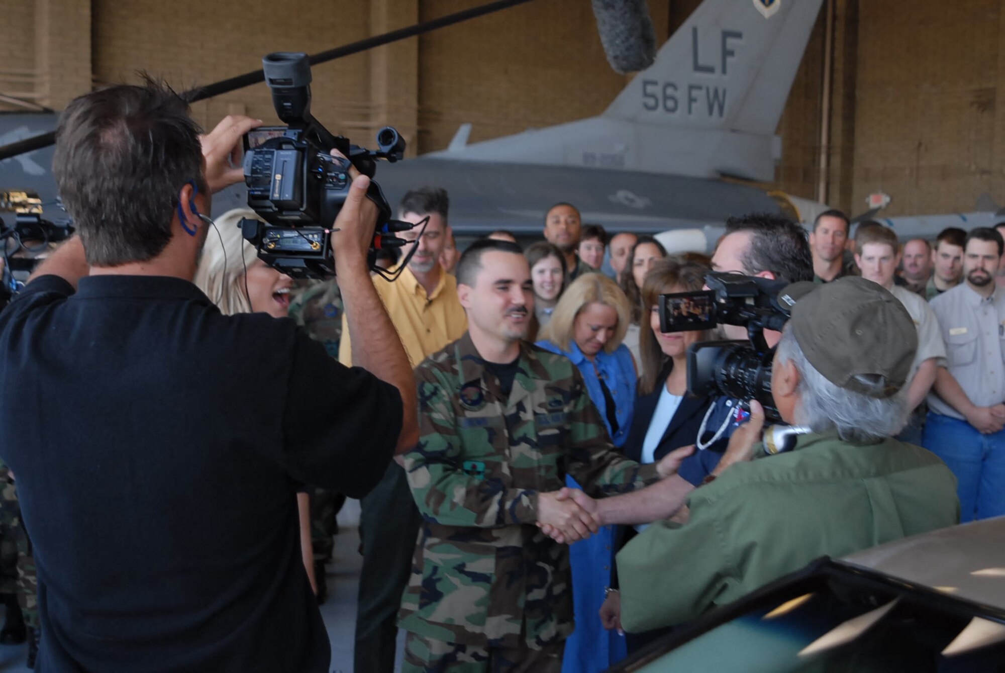 Tech. Sgt. Keith Brown, 56th Logistics Readiness Squadron Vehicle Operations supervisor, expresses his surprise when NASCAR Angels host, Shannon Wiseman, presents him with a custom 2001 Oldsmobile Alero, as his family and more than
60 56th LRS Airmen cheer him on. The NASCAR Angels originally intended to repair Sergeant Brown’s 1993 Nissan NX 1600, but the unavailability of parts prompted the show to present Sergeant Brown and his family with another car. The Browns
were also given camping equipment courtesy of Cabela’s sports retailer. (Photo by Staff Sgt. Phillip Butterfield)