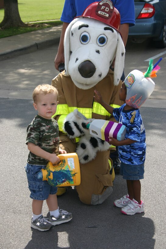 Sparky the Fire Dog says hello to Tyler Zukowski (left) and Ciara Monroe during the Child Development Center's Month of the Military Child Parade April 19.  (U.S. Air Force photo/Staff Sgt. Tonnette Thompson)