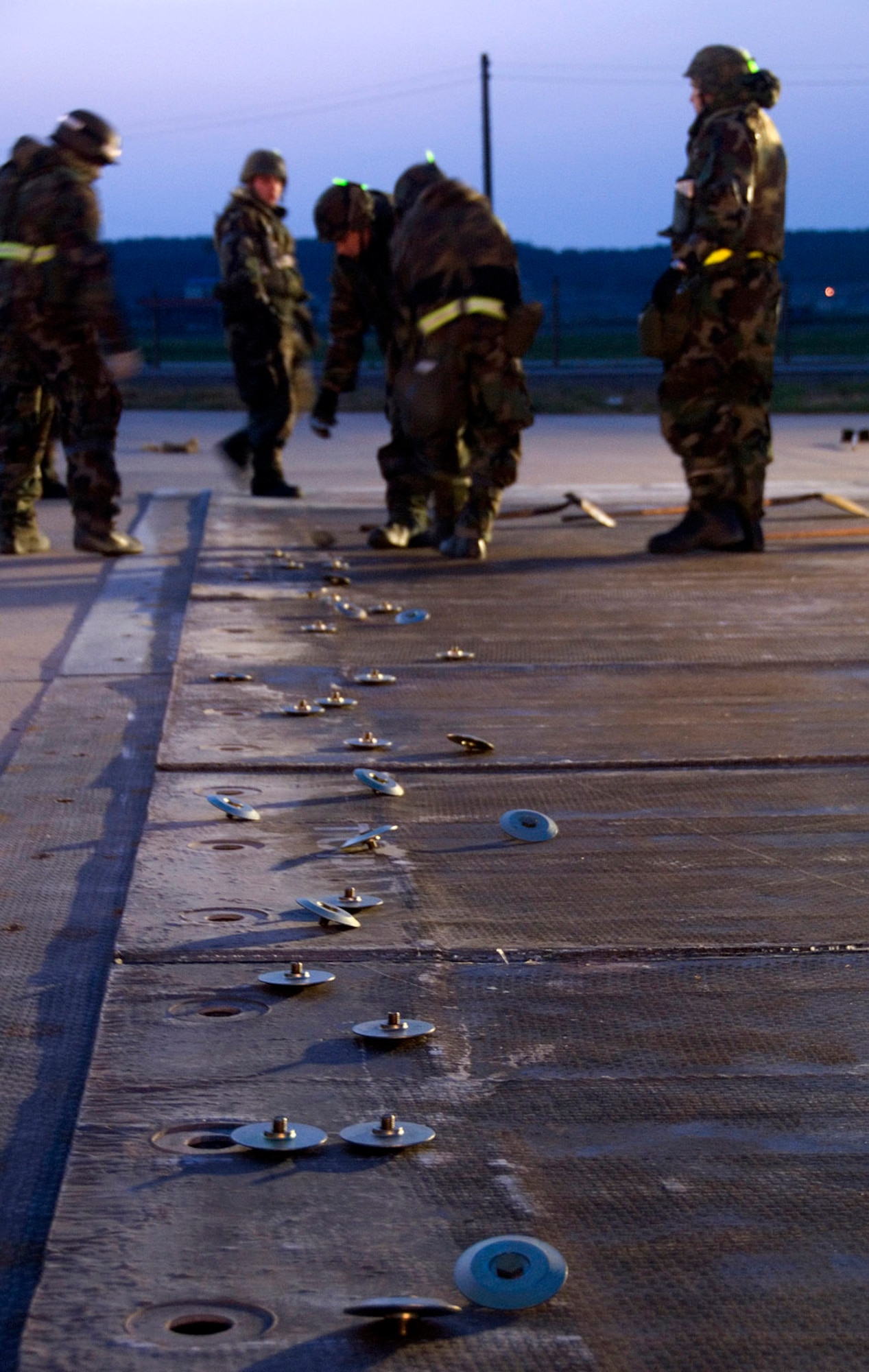 Members of the 8th Civil Engineer Squadron Airfield Damage Repair team install bushings in fiberglass matting April 19 at Kunsan Air Base, South Korea. The ADR teams perform several functions during exercises, including crater repair after simulated attacks and airfield lighting during simulated power outages, making it possible to get aircraft back in the air quickly. Kunsan AB is currently undergoing an Operational Readiness Inspection to test the 8th Fighter Wing's ability to conduct its wartime mission. (U.S. Air Force photo/Master Sgt Jack Braden)