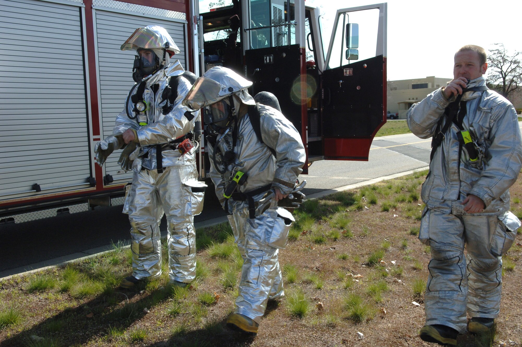 Senior Airman Kristopher Doughty, Jason Stacher and John Adams arrive at a simulated disaster area April 19 during an exercise at Fairchild Air Force Base, Wash. The exercise is intended to test the base's ability to respond to a weapon of mass destruction. Airman Doughty, Mr. Stacher and Mr. Adams are all members of the 92nd Civil Engineer Squadron. (U.S. Air Force photo/Airman 1st Class Jocelyn Ford)