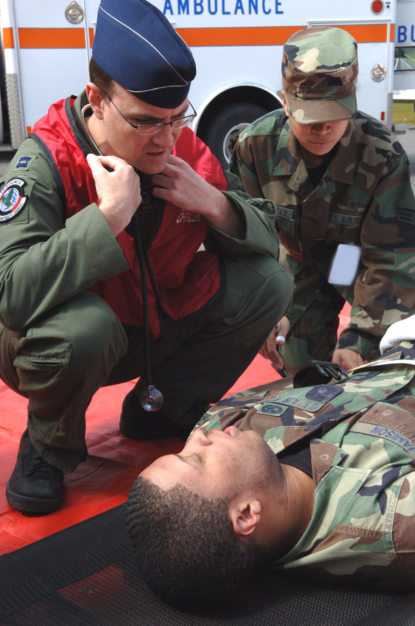 Capt. Jared Kelstrom and Senior Airman Karen Caminggay, evaluate Airman 1st Class Antwuan Jamison, and prepare to measure his vital signs. Airman Jamison was one of the personnel wounded by a simulated weapon of mass destruction during an exercise April 19 at Fairchild Air Force Base, Wash. Captain Kelstrom is with the 92nd Aeromedical Dental Squadron. Airman Caminggay is assigned to the 92nd Medical Support Squadron. Airman Jamison is with the 92nd Logistics Readiness Squadron. (U.S. Air Force photo illustration/Airman 1st Class Jocelyn Ford)