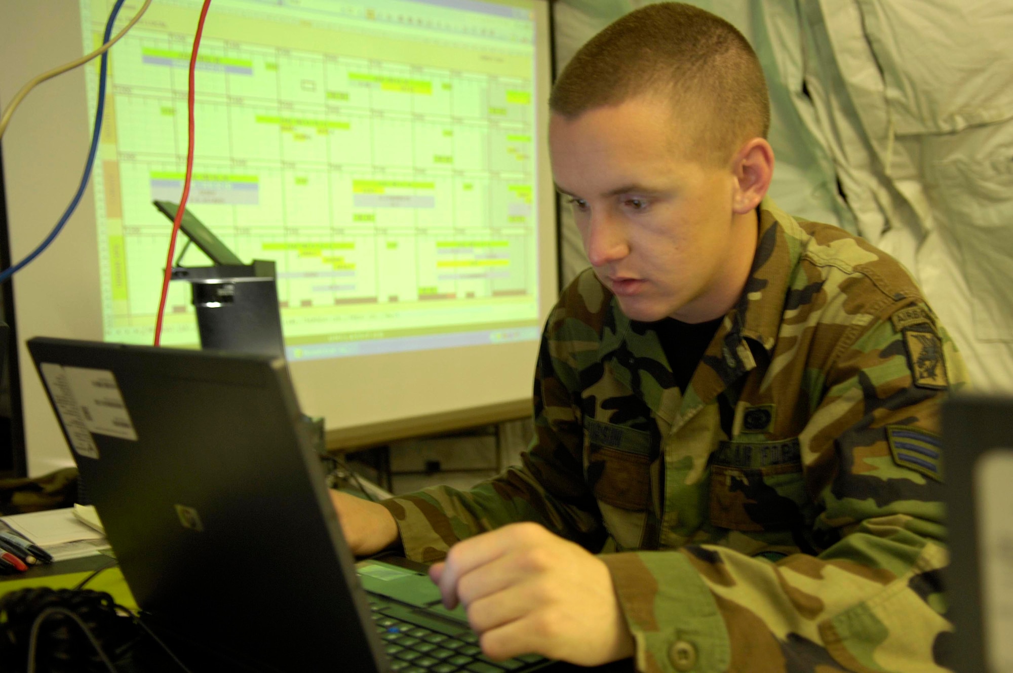 Senior Airman Grant Hursin, a Tactical Air Control Party member, reviews intelligence collected from the previous day's missions April 18 to piece together a new, current briefing for Atlantic Strike V. Airman Hursin is assigned to the 682nd Air Support Operations Squadron at Shaw Air Force Base, S.C. Atlantic Strike is a semi-annual joint forces training event involving Joint Terminal Attack Controllers from the Air Force, Army and Marines. The event is held at Avon Park Air Ground training Complex in Avon Park, Fla. (U.S. Air Force photo/Staff Sgt. Stephen J. Otero)