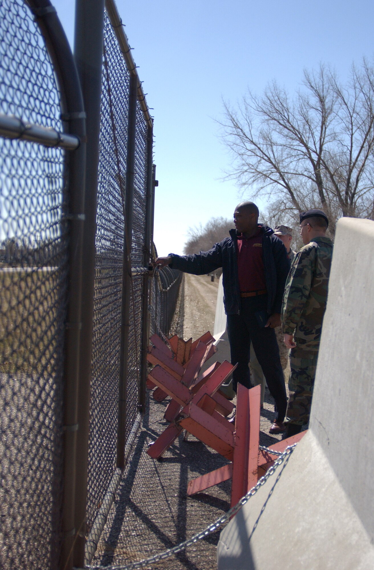 GRAND FORKS AIR FORCE BASE, N.D. ? Mr. Marion Andrews, an instructor with the Defense Threat Reduction Agency, inspects a barricaded, unused gate here April 19 during a field exercise as part of a five-day conference.  More than 93 instructors and students (enlisted, officers and civilians from every branch of the military) were here for an anti-terrorism, threat-reduction conference that covered terrorist options, security operations, structural engineering and security engineering, infrastructure engineering and emergency management.  (U.S. Air Force photo/Senior Airman J. Paul Croxon)
