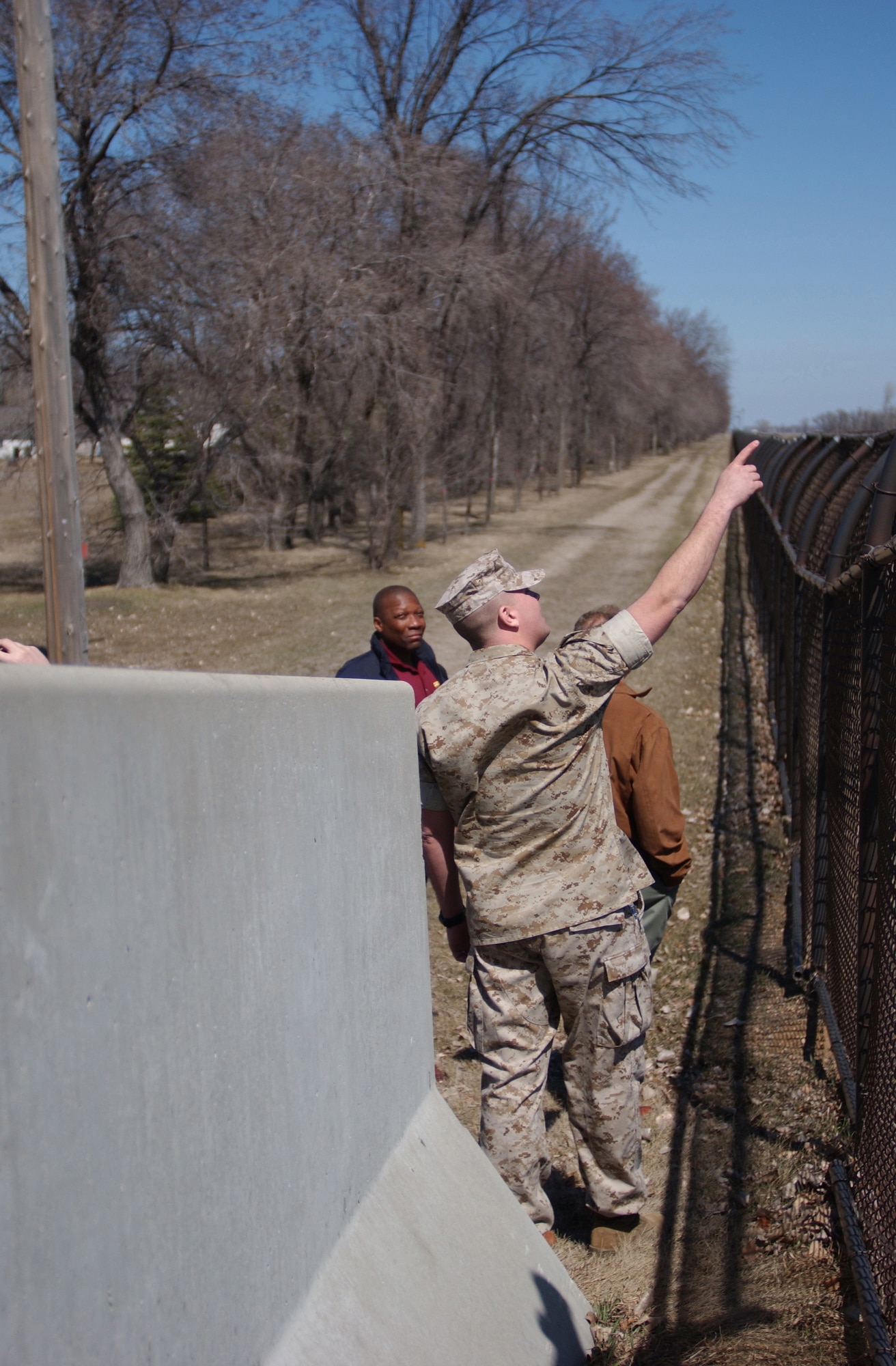 GRAND FORKS AIR FORCE BASE, N.D. ? Marine Sgt. Geoffrey Kruse, assesses the base fence during a field exercise as part of a five-day anti-terrorism, threat reduction conference here April 19. More than 93 instructors and students (enlisted, officers and civilians from every branch of the military) attended the conference that covered terrorist options, security operations, structural engineering and security engineering, infrastructure engineering and emergency management. (U.S. Air Force photo/Senior Airman J. Paul Croxon)
