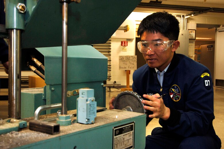 Senior Jae-Hyun Park cuts a part for the upcoming vibration test of Falcon Satellite-5. The satellite is being designed and built at the U.S. Air Force Academy in Colorado Springs, Colo. It will be tested and operated by the cadets through the USAFA Space Systems Research Center. (U.S. Air Force photo/Mike Kaplan)