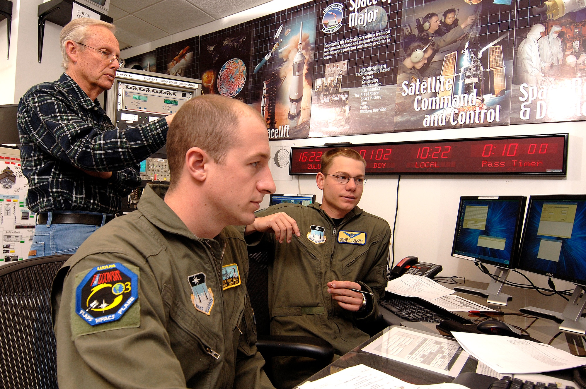 Senior cadets Christopher Odell and Phillip Stewart verify with technical staff member John Clark April 12 that their software is correctly configured before the next pass of Falcon Satellite-3 at the U.S. Air Force Academy in Colorado Springs, Colo. FalconSAT-3 is undergoing testing 100,000 feet from Earth in preparation for experiments involving space weather and spacecraft operations. The satellite was designed and built, by Academy cadets who now test and operate it. The project is administered by the USAFA Space Systems Research Center. (U.S. Air Force photo/Mike Kaplan)
