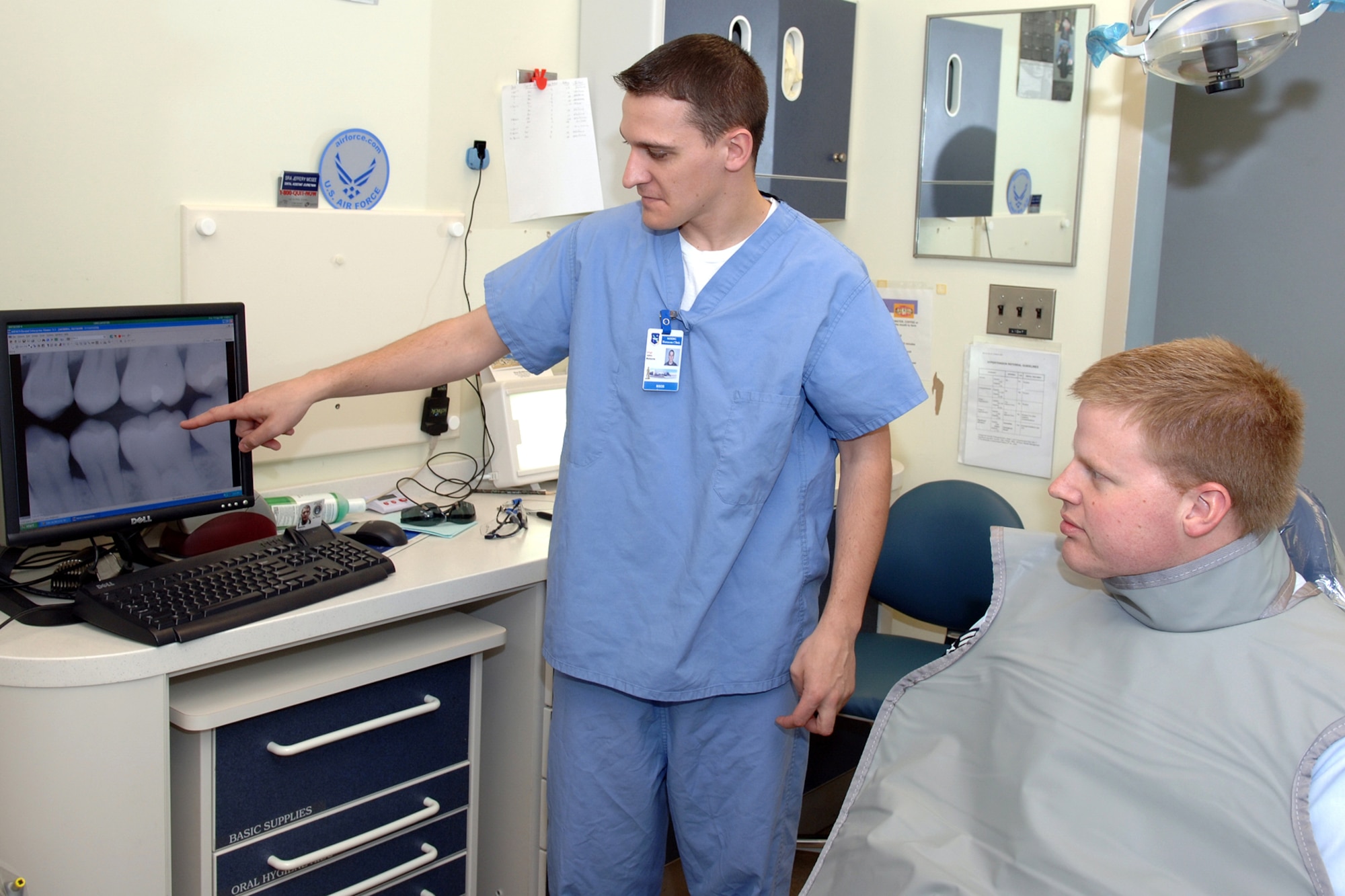 HANSCOM AFB, Mass -- From left, Staff Sgt. John Malzone, 66th Medical Group Dental Flight, shows Tech Sgt. Raymond Merring, 66 MDG Dental Flight, his X-rays, which were taken using the new digital radiography system that was recently installed at Hanscom. (U.S. Air Force photo by Jan Abate)