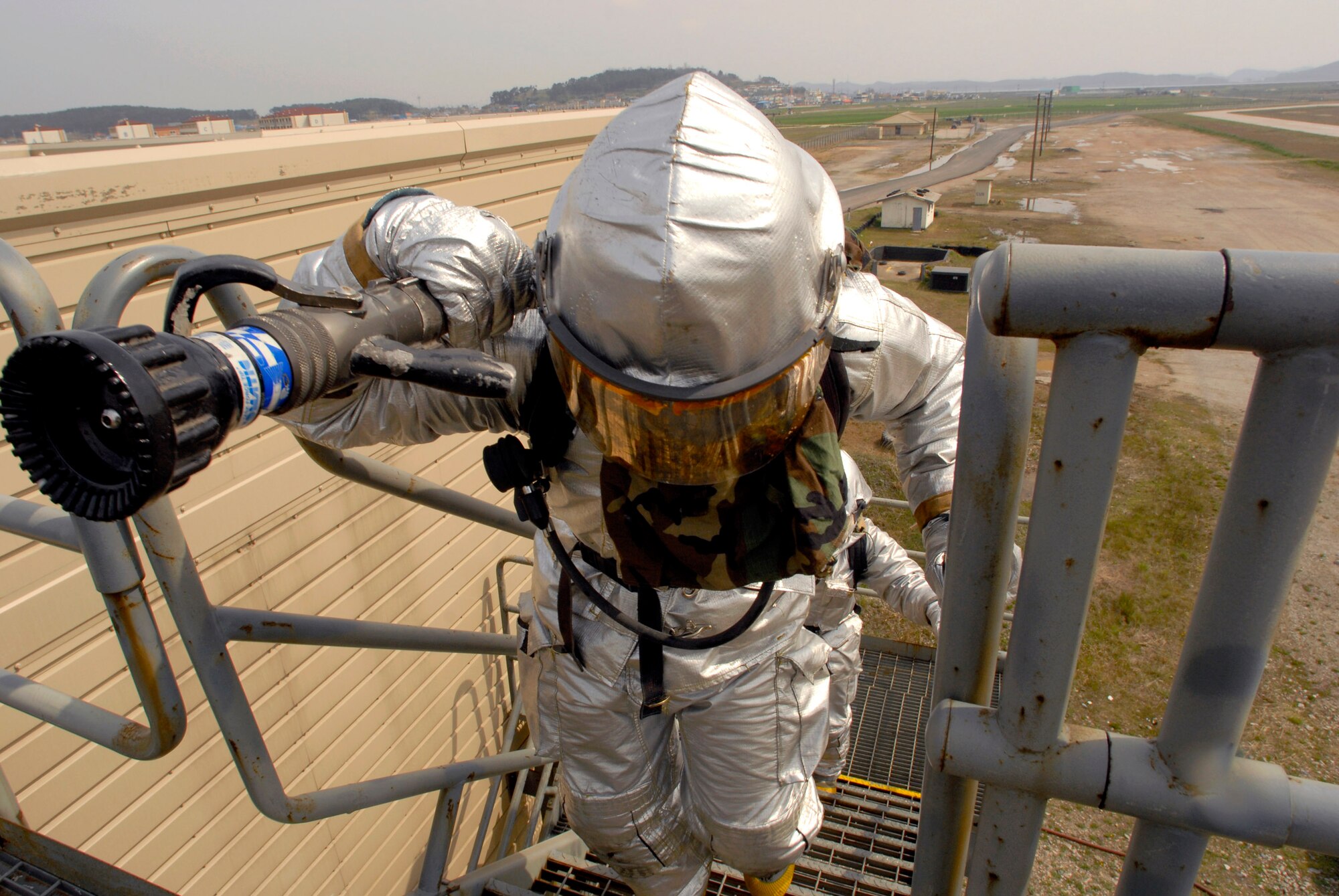 Senior Airman James Lionel from the 8th Civil Engineer Squadron climbs stairs to respond to a simulated fire during an operational readiness inspection April 17 at Kunsan Air Base, South Korea. Kunsan AB is currently undergoing an operational readiness inspection to test the 8th Fighter Wing's ability to conduct its wartime mission. (U.S. Air Force photo/Senior Airman Barry Loo) 
