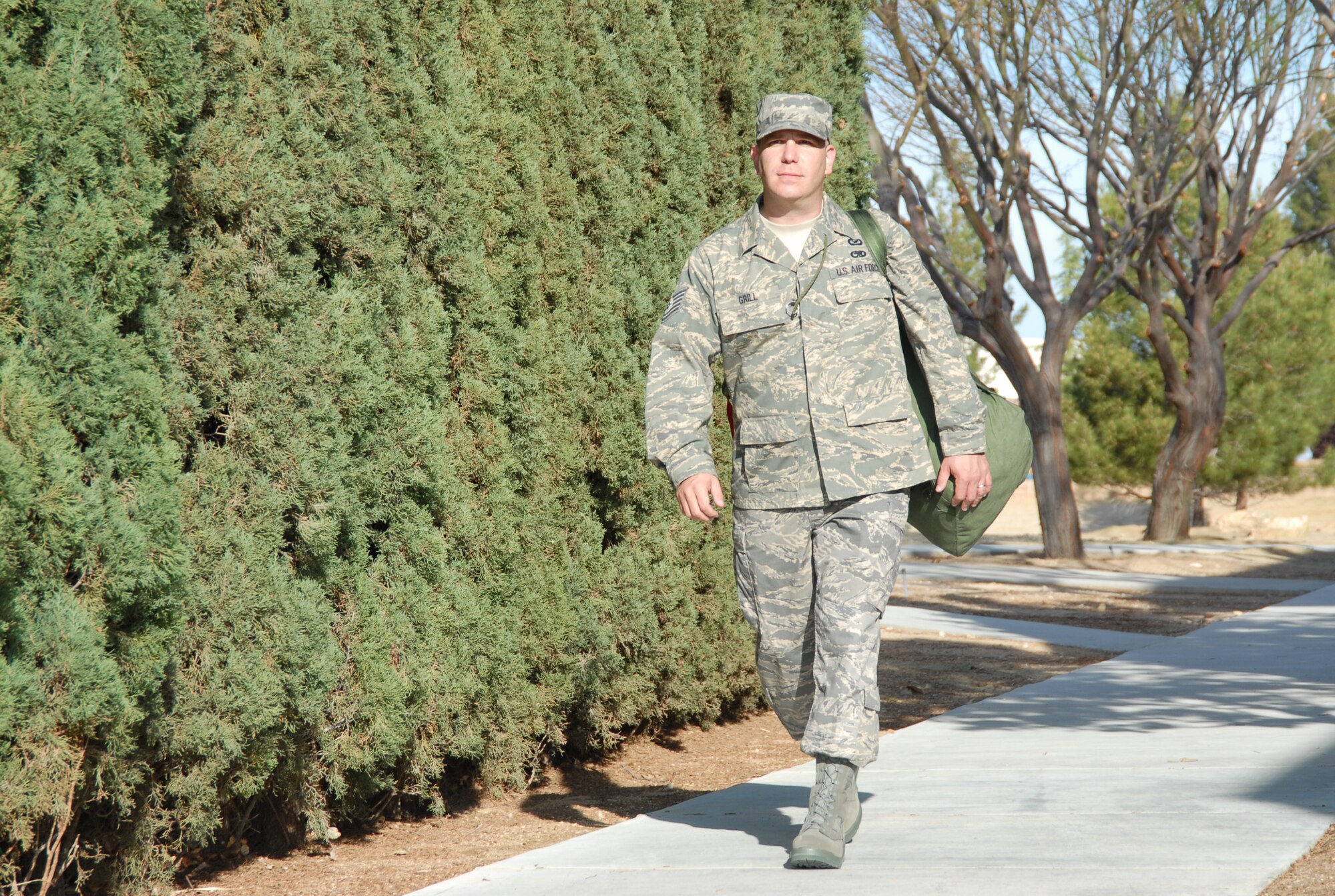 EDWARDS AIR FORCE BASE, Calif. -- Tech. Sgt. Eric Grill, 95th Air Base Wing Public Affairs noncommissioned officer in charge, carries his duffle bag in preparation for an upcoming deployment to Southwest Asia. Sergeant Grill is the first Edwards Airman to deploy with the new Airman Battle Uniform. The mandatory wear date for the new uniform is Oct. 1, 2011. (Photo by Senior Airman Jason Hernandez)