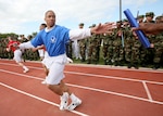 A mile relay runner for the 331st Training Squadron grabs the baton as spectators cheer him on during the Warrior Challenge April 14 on Lackland Air Force Base, Texas. The monthly physical fitness competition among the six squadrons includes six events. The 326th TRS was the overall winner this month. (USAF photo by Robbin Cresswell)