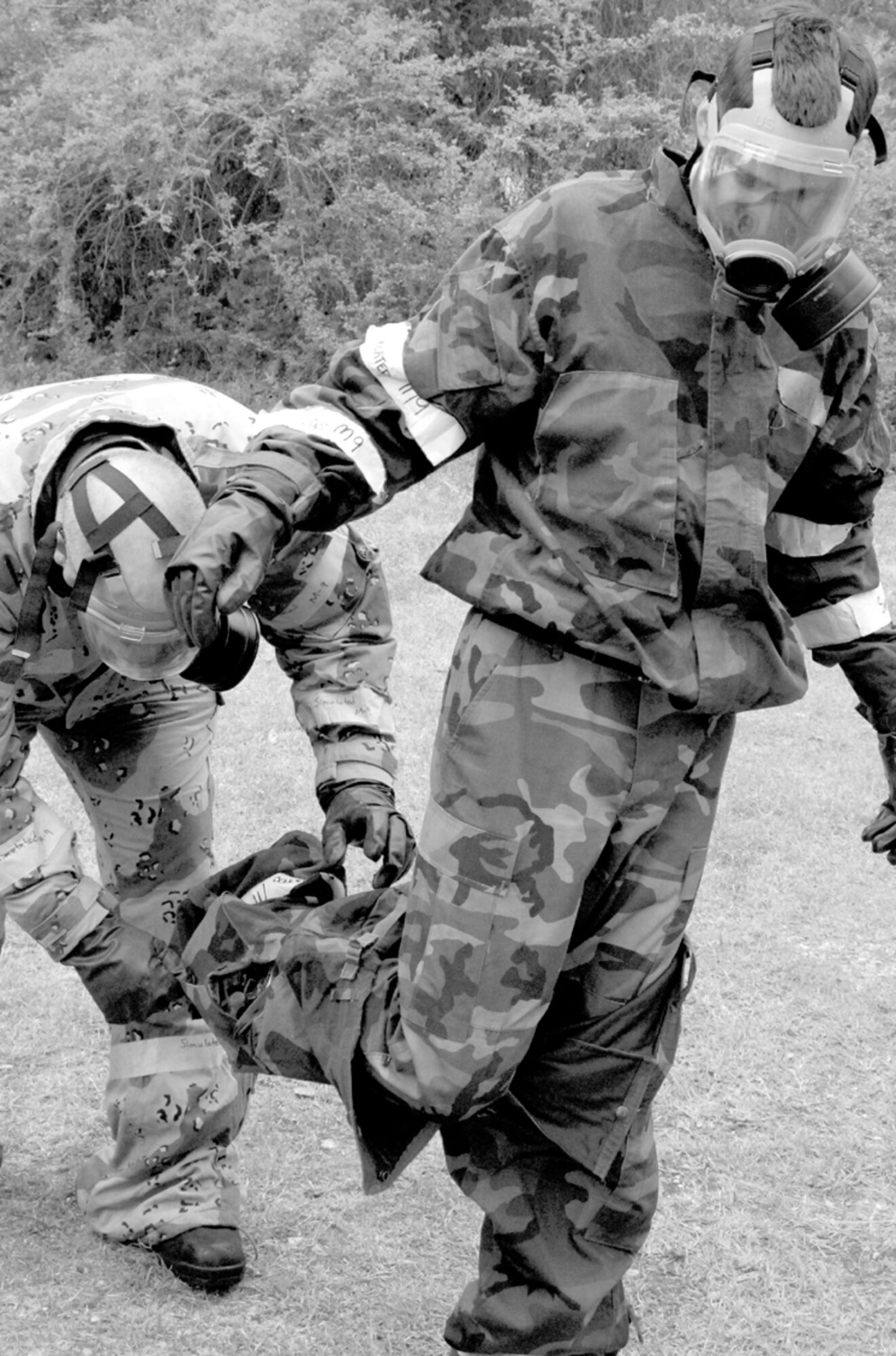 Tech. Sgt. Michael Clark helps Senior Airman Richard Brashertake his chemical gear off through the contamination control area line Wednesday during a base exercise. The CCA took place at the 43rd Civil Engineer Squadron readiness flight. Both Airmen are with the 43rd Comptroller Squadron.