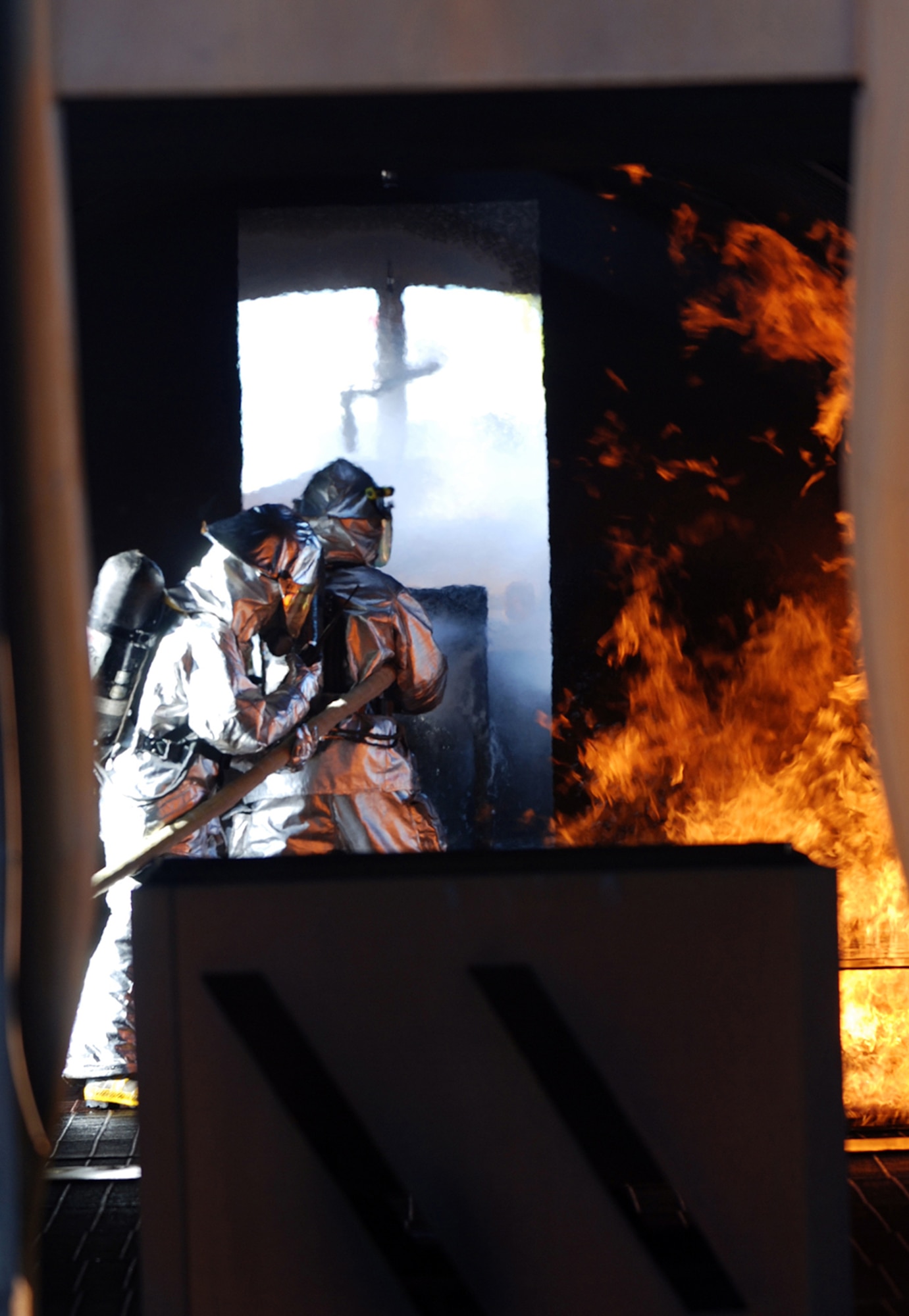 McConnell firefighters extinguish a fire in the cockpit of a mach aircraft, April 11, during a live-fire training exercise on base. Firefighters from the 22nd Civil Engineer Squadron and the Kansas Air National Guard participated in the exercise. (Photo by Airman 1st Class Jessica Lockoski)