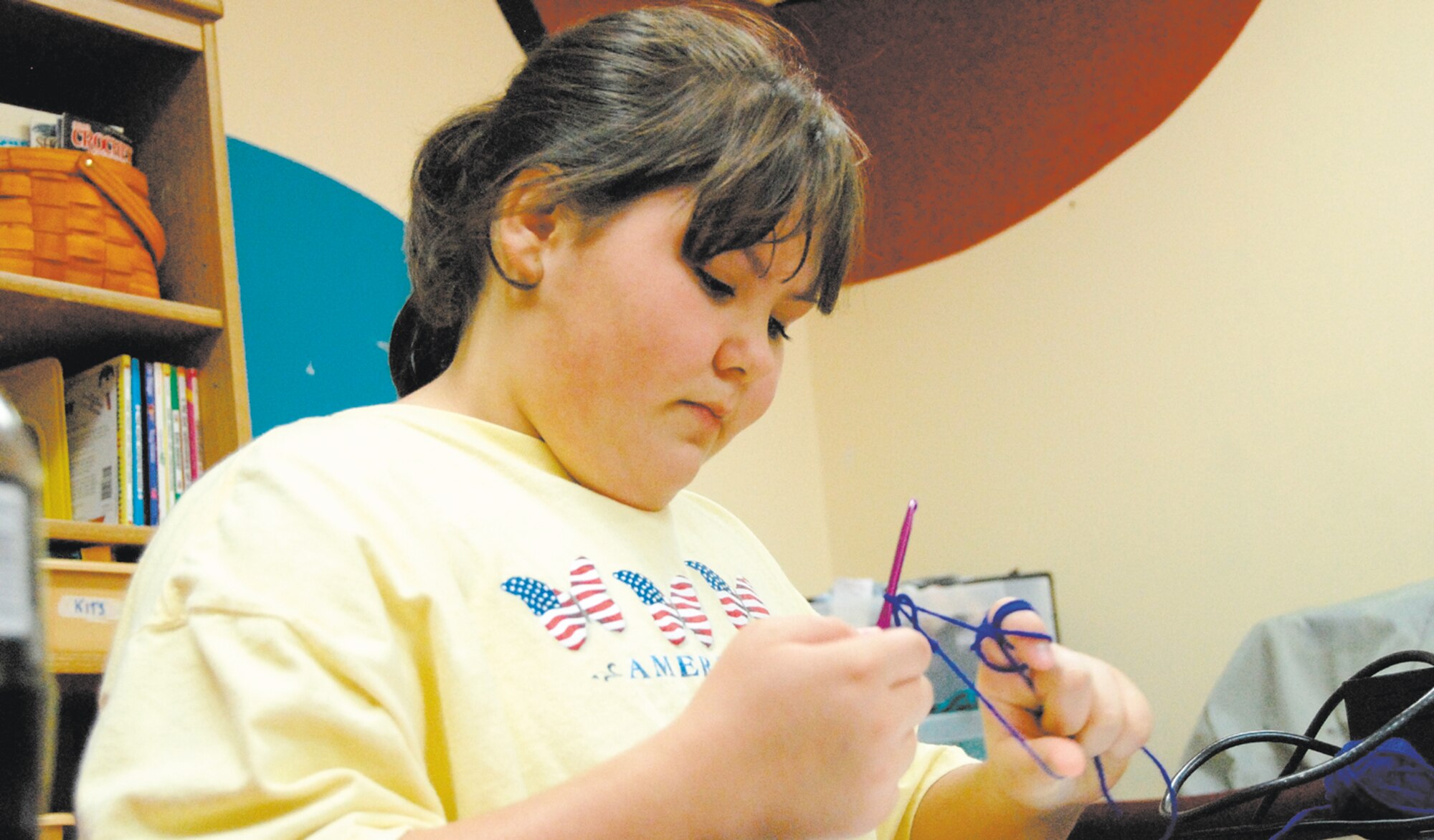 Taylor Degreen, regional winner of the Boys and Girls Club Fine Arts Contest, crochets a bracelet in the art room at the Youth Center April 13. Taylor will go on to complete against five other regions in the nation. Taylor Degreen is the daughter of Master Sgt. Merril Degreen and Katina Degreen. Taylor loves to read and has recently read two books over spring break. She wants to learn French and Spanish and one day hopes to be a crime scene investigator, a vocation inspired by her favorite television show CSI.