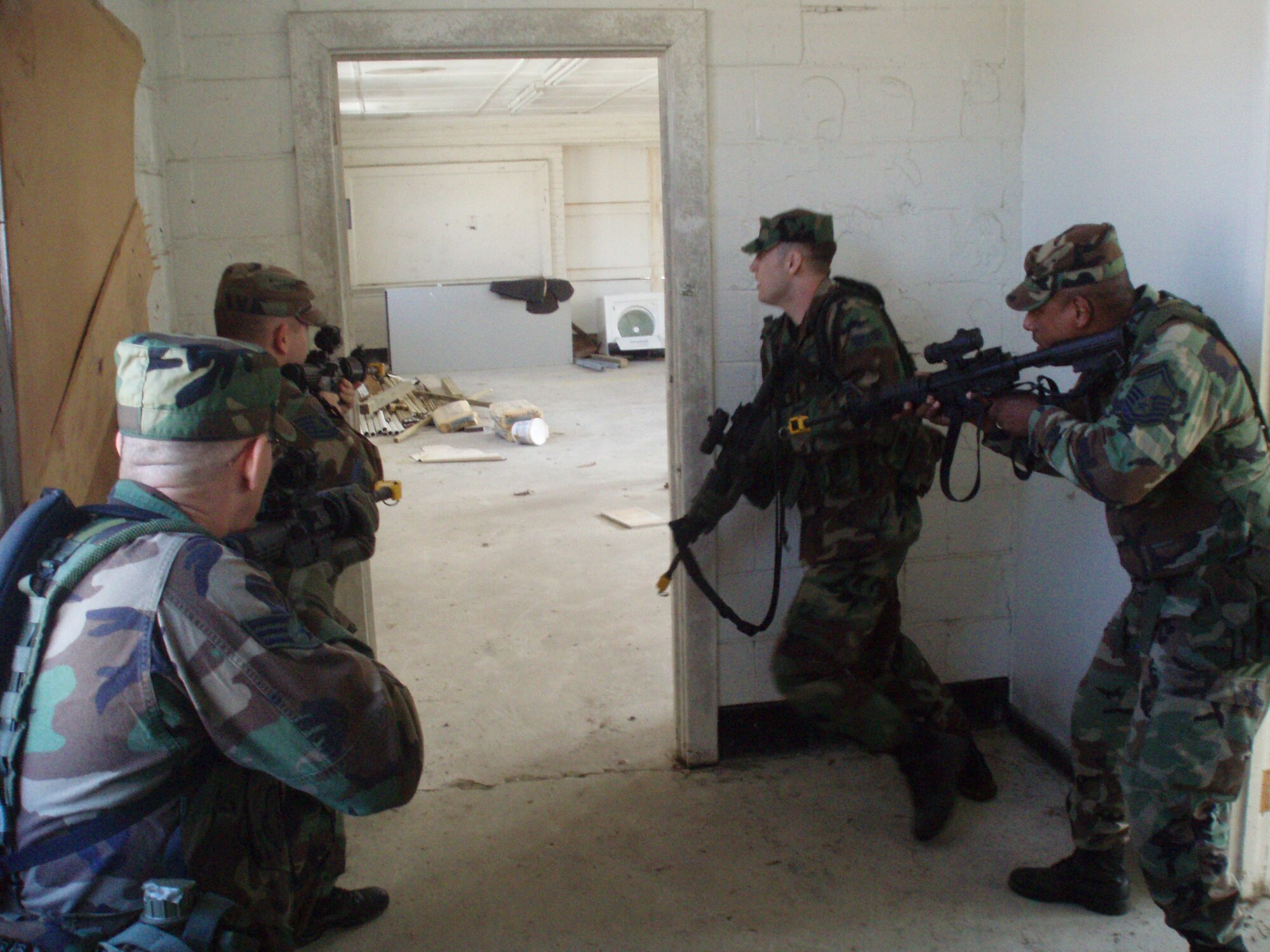 Fifteen Security Forces members from the 916th Air Refueling Wing, Air Force Reserve, spent a weekend in March training with the Marines. The Marine Corp Reserve Support Company helps reservists prepare for real-world deployments. Pictured here: SrA Greg Buie, SrA Tony Jones, TSgt. Brian Murawski and SMSgt. Ron McKenzie practice room clearing operations. The training was invaluable as these members prepare for deployment in August 2007. (U.S. Air Force Photo/Maj. Jeff Poupart)
         