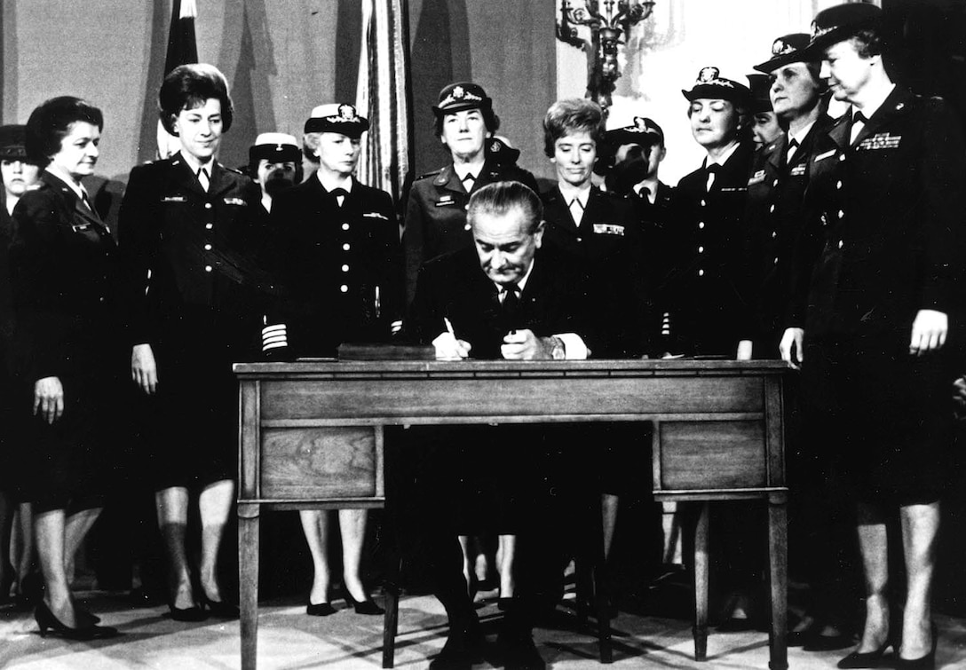 President Lyndon B. Johnson signs Public Law 90-130. The Nov. 8, 1967, event opened promotions for women to general and flag ranks, lifted ceilings on other ranks and removed the 2 percent ceiling on the number of women allowed on active duty. Courtesy Women's Memorial