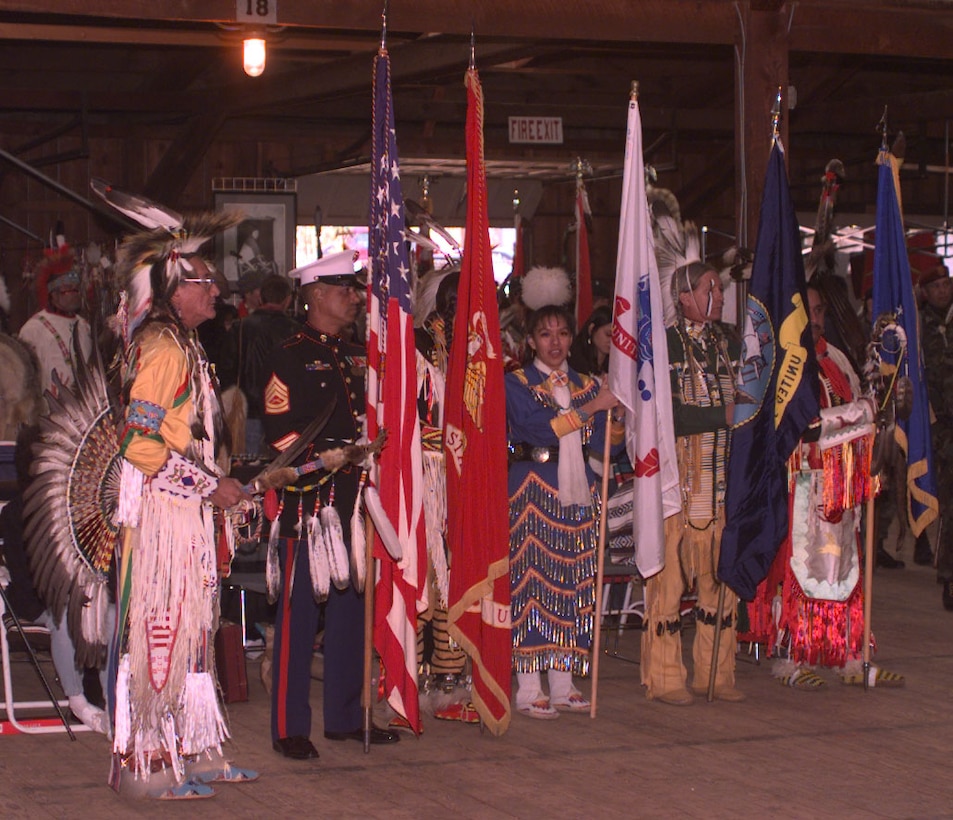 Gunnery Sgt. Randall Arnold (North Carolina Eastern Band Cherokee) of Quantico (Va.) Marine Corps Base carried the American flag during the grand entry of the National Native American Veterans Powwow. To his left is Vietnam veteran retired Army Master Sgt. Marvin Burnette of the Rosebud, S.D., Lakota tribe was the lead powwow dancer. Rudi Williams