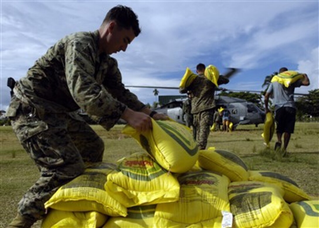 U.S. Marine Corps Lance Cpls. Jeffrey A. Rapp and Nathan G. Seither load rice into a U.S. Navy HH-60H Seahawk helicopter in Gizo, Solomon Islands, for delivery to outlying islands on April 19, 2007.  Rapp, Seither and other Marines embarked with USNS Gunnery Sgt. Fred W. Stockham (T-AK 3017) are helping with humanitarian assistance operations after two earthquakes and a tsunami struck the Solomon Islands on April 2nd.  Rapp and Seither are both assigned to the 1st Platoon, 2nd Fleet Antiterrorism Security Team Company.  