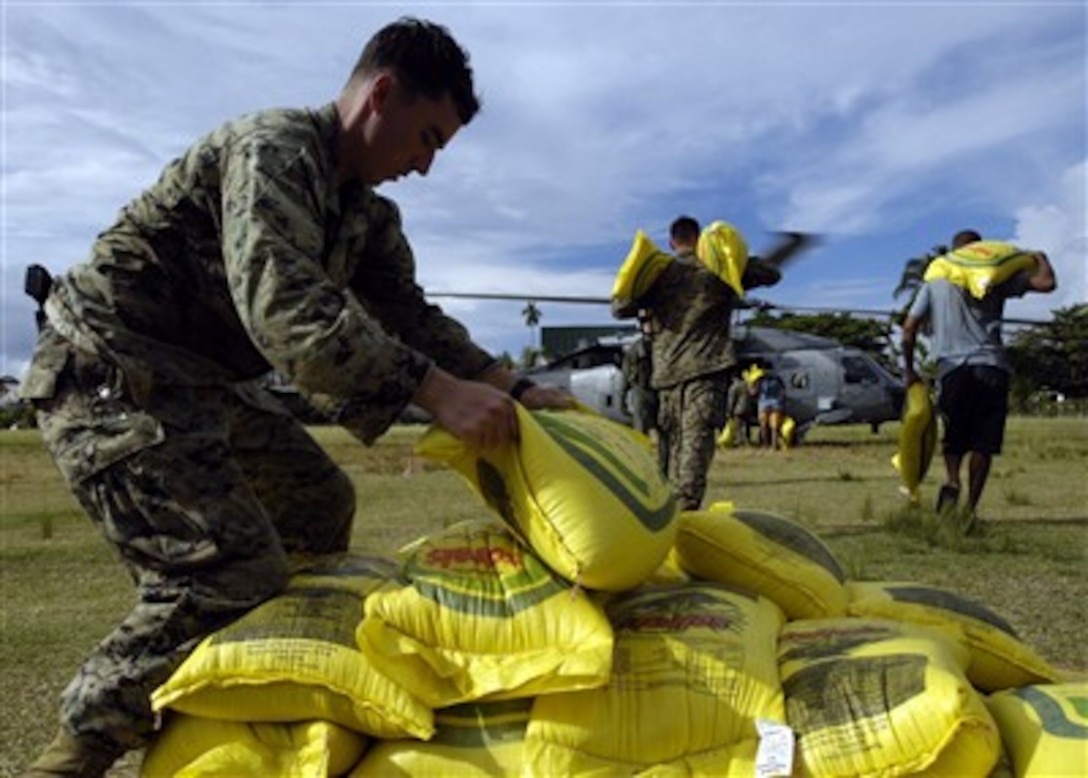 U.S. Marine Corps Lance Cpls. Jeffrey A. Rapp and Nathan G. Seither load rice into a U.S. Navy HH-60H Seahawk helicopter in Gizo, Solomon Islands, for delivery to outlying islands on April 19, 2007.  Rapp, Seither and other Marines embarked with USNS Gunnery Sgt. Fred W. Stockham (T-AK 3017) are helping with humanitarian assistance operations after two earthquakes and a tsunami struck the Solomon Islands on April 2nd.  Rapp and Seither are both assigned to the 1st Platoon, 2nd Fleet Antiterrorism Security Team Company.  