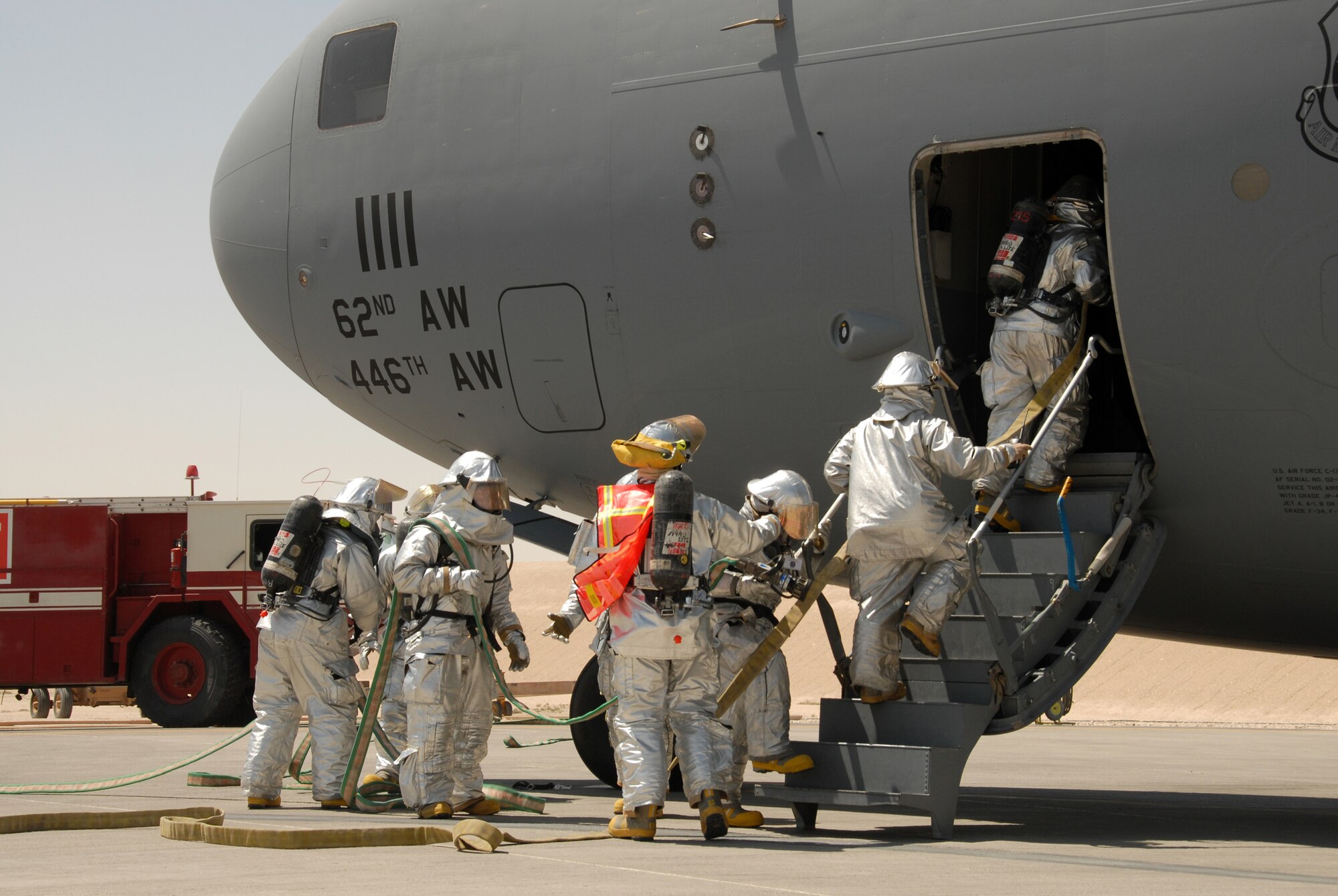 Firefighters from the 379th Expeditionary Civil Engineer Squadron Fire and Emergency Services Flight practice entering a C-17 Globemaster with the necessary tools and equipment to rescue crewmembers and extinguish an interior fire during an exercise Monday. The hands-on training ensures firefighters are ready to deal with any type of emergency. Firefighters must be proficient in properly shutting-down aircraft engines, activating and discharging the on-board fire suppression system, turning off the “master” power switch, and properly opening all emergency exits, doors and windows. (U.S. Air Force photo by Airman 1st Class Gustavo Gonzalez)