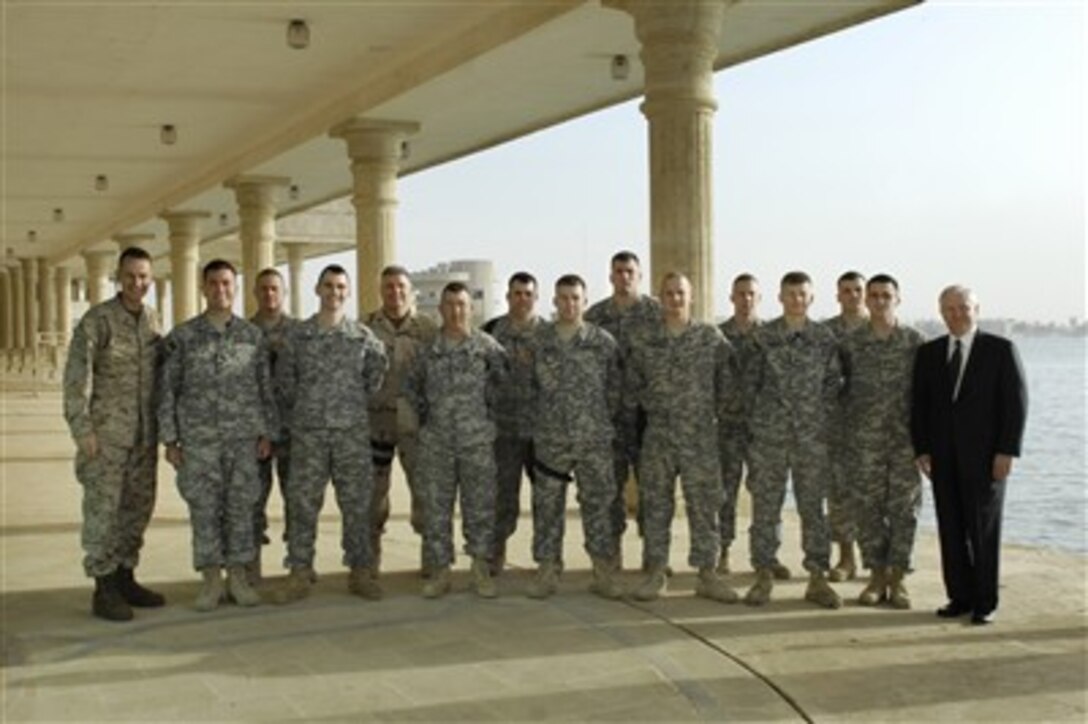 Chairman of the Joint Chiefs of Staff U.S. Marine Gen. Peter Pace, left, and Defense Secretary Robert M. Gates, right, take a group photo with members of the Kentucky Army National Guard currently serving in Baghdad, April 20, 2007. 